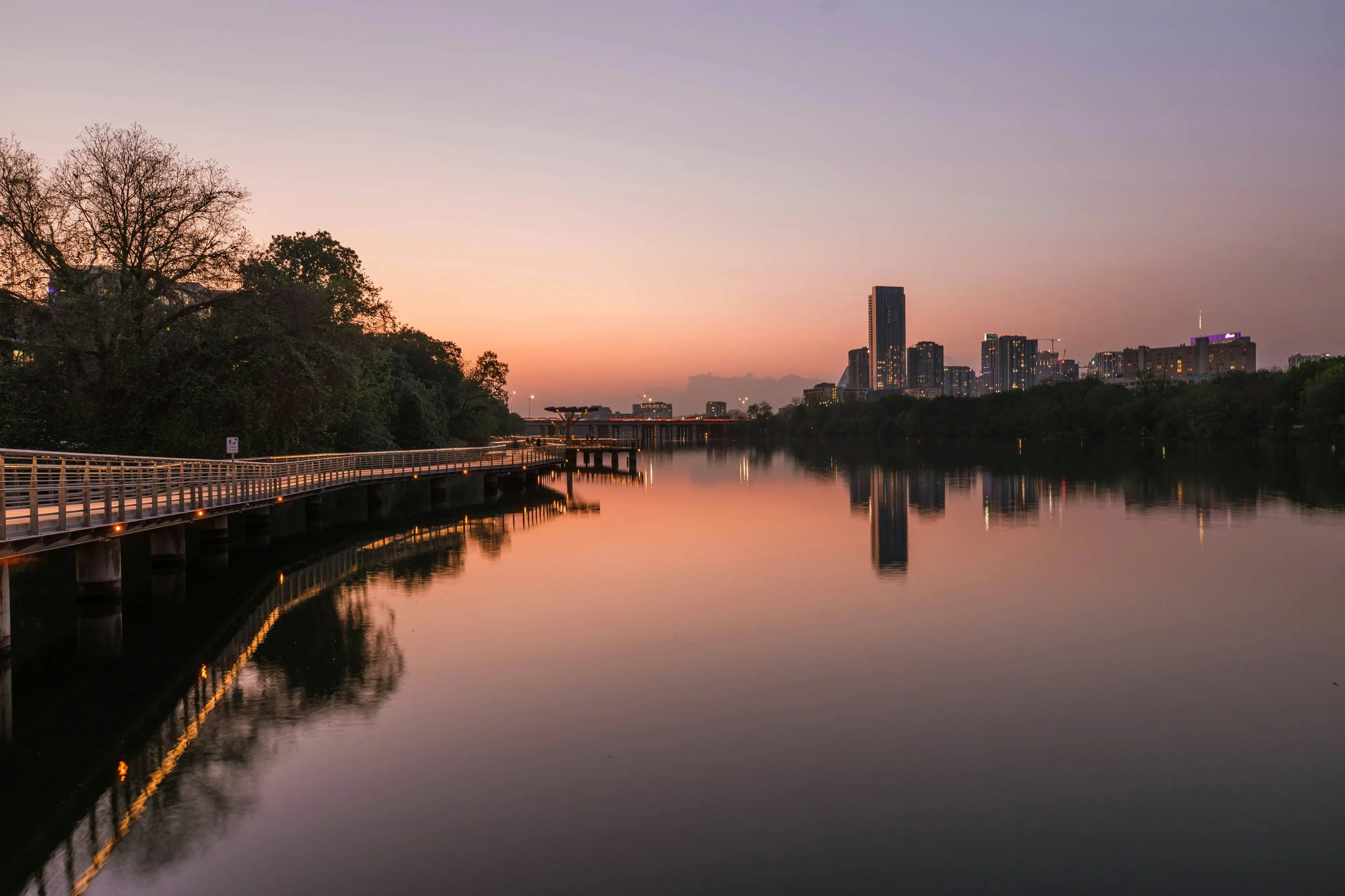 Austin Texas waterfront under a soft sunrise sky