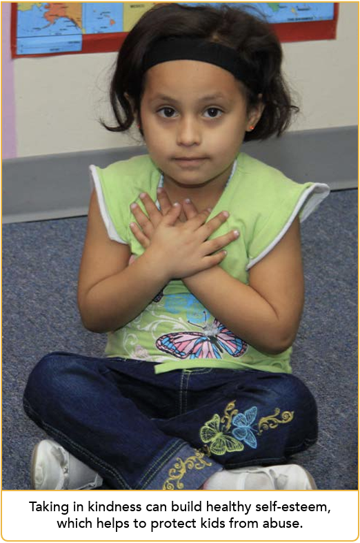 Young child sitting on floor with hands crossed over her heart. Text: Taking in kindness can help build healthy self-esteem, which helps to protect kids from abuse.