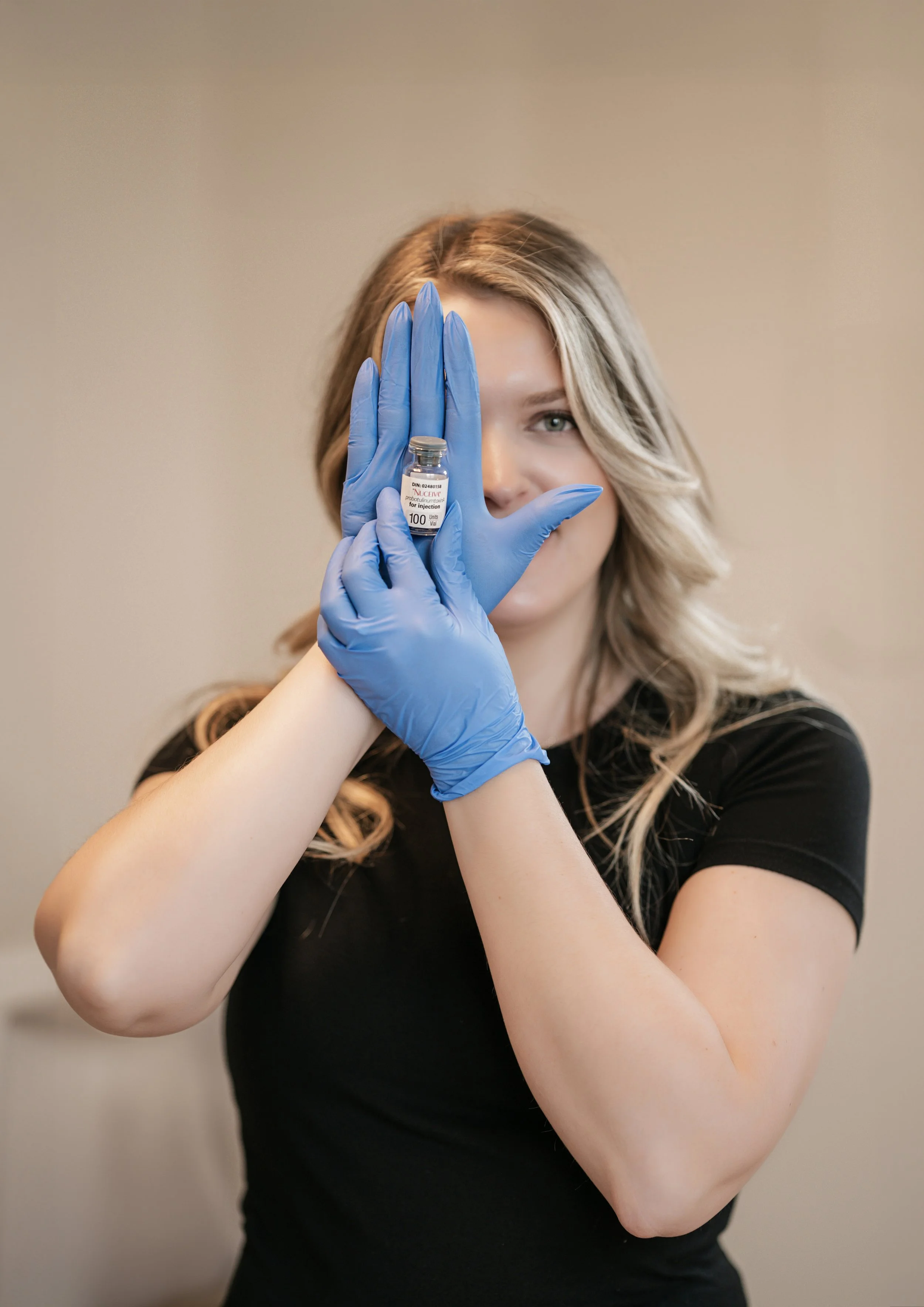 Creative branding portrait of a beauty business owner holding a skincare product with luxury wellness studio aesthetics.