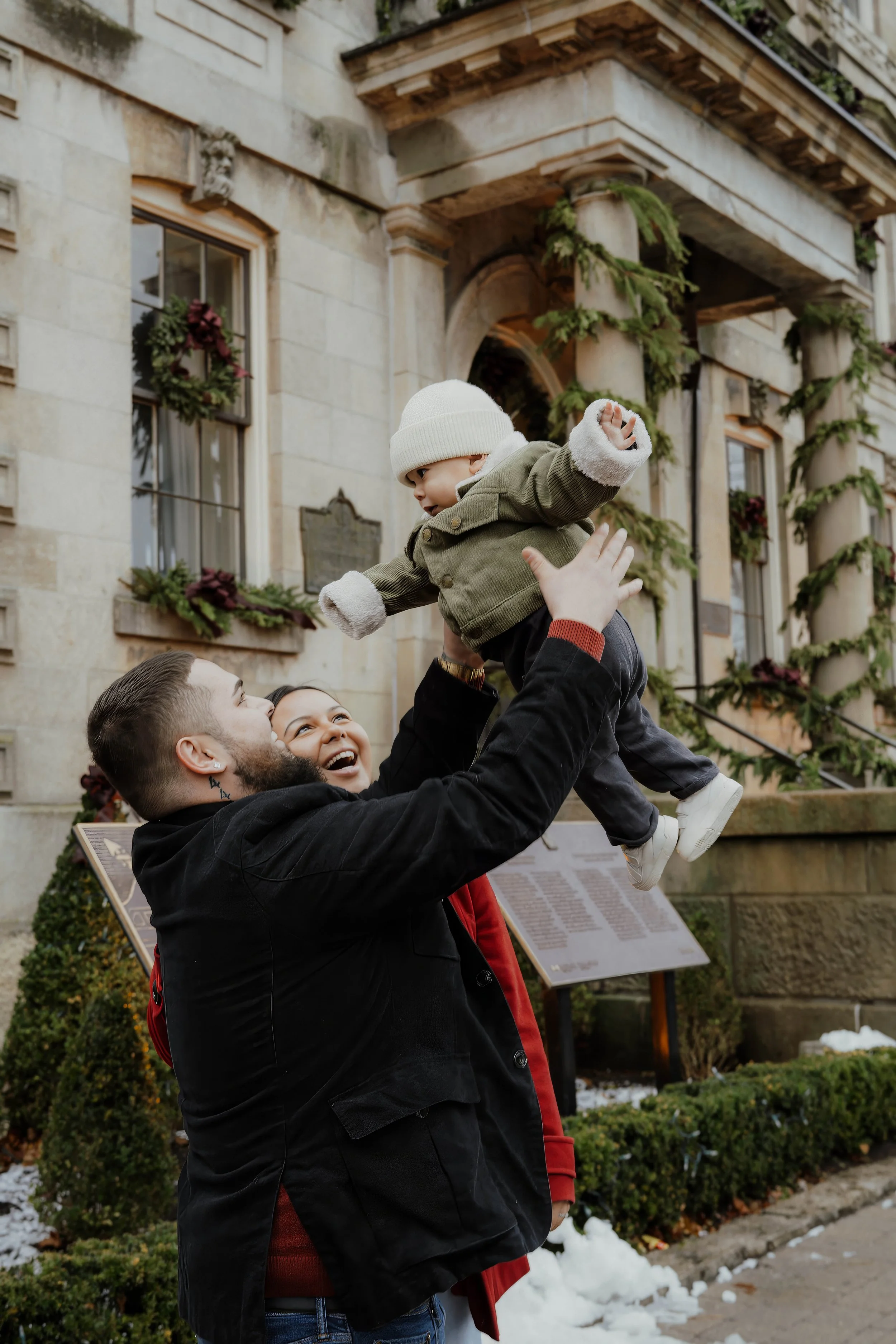 Family Christmas mini session in Niagara-on-the-Lake with parents playing with their baby surrounded by festive holiday decorations.