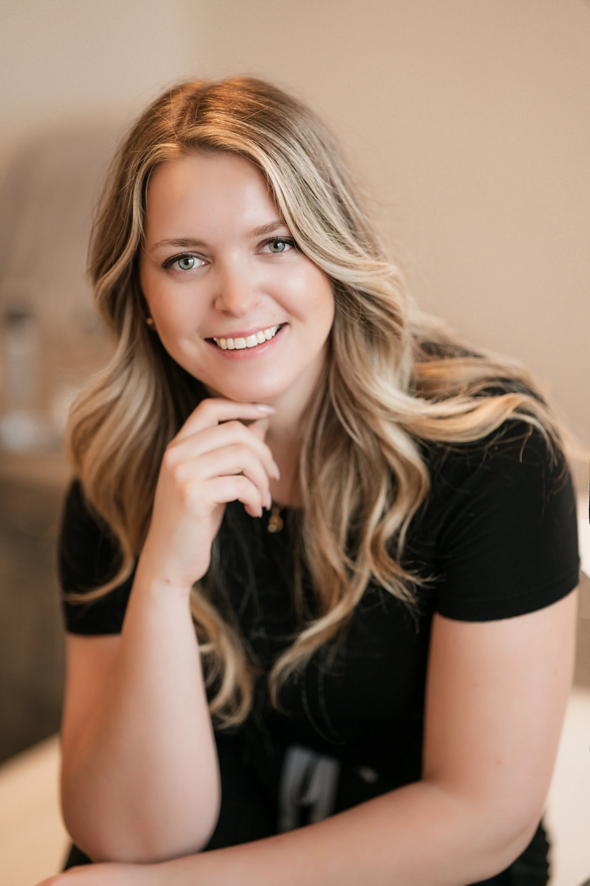 Professional branding portrait of a female beauty business owner with soft natural lighting and luxury wellness studio aesthetics.