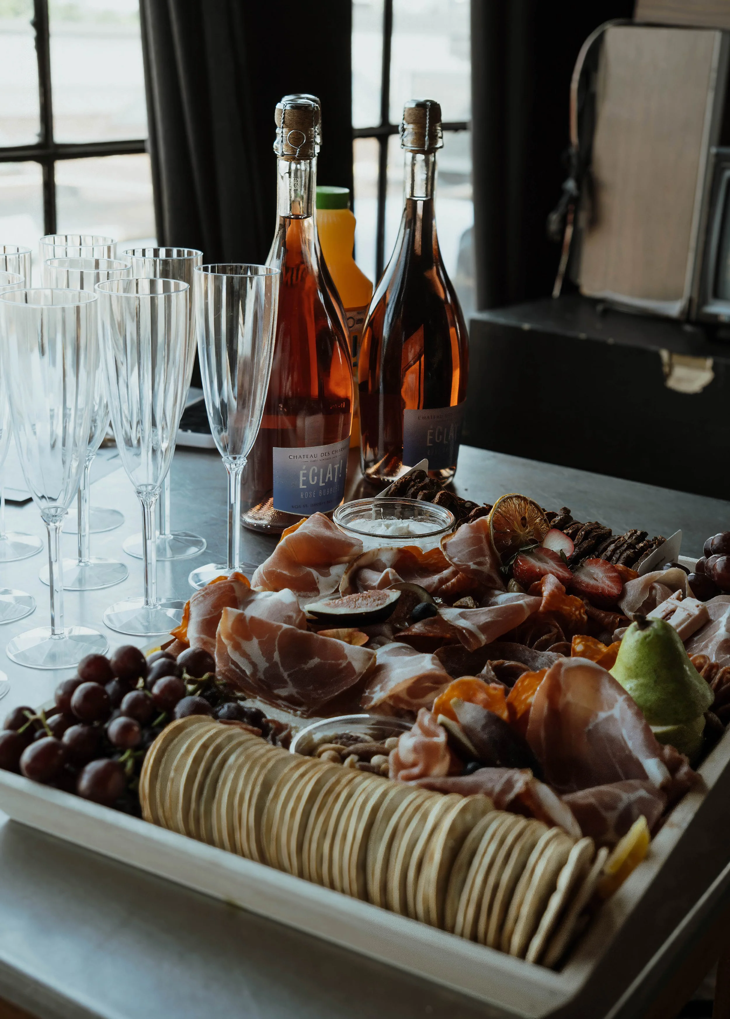 Château des Charmes Éclat Rosé sparkling wine bottles with champagne glasses and a charcuterie spread, prepared for a Toronto Olympic athlete editorial photoshoot.