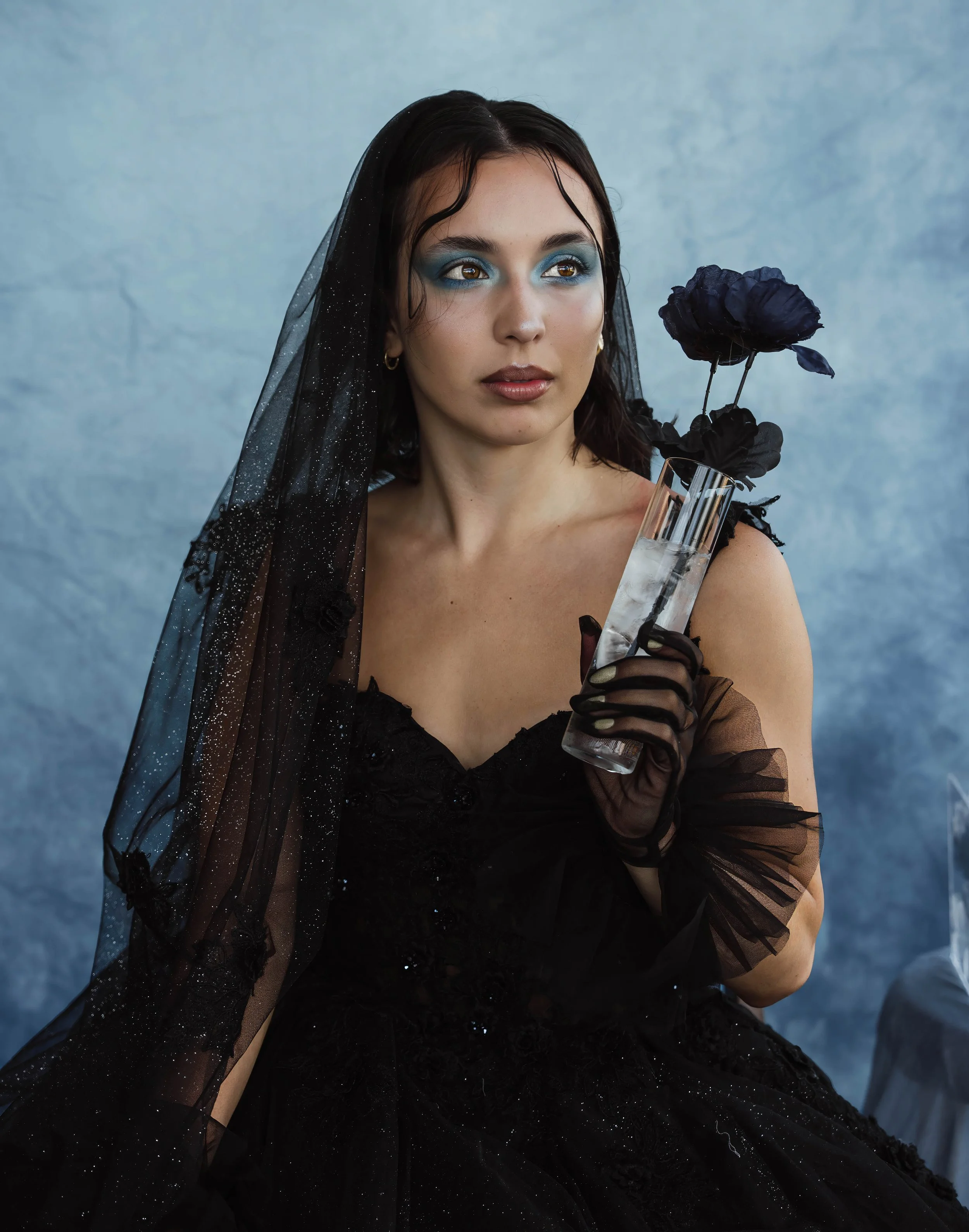 Figure skater Lia Pereira photographed in a black editorial gown and veil holding a floral ice arrangement during Lara Grace Creative Studio’s Olympic athlete photoshoot in Toronto.