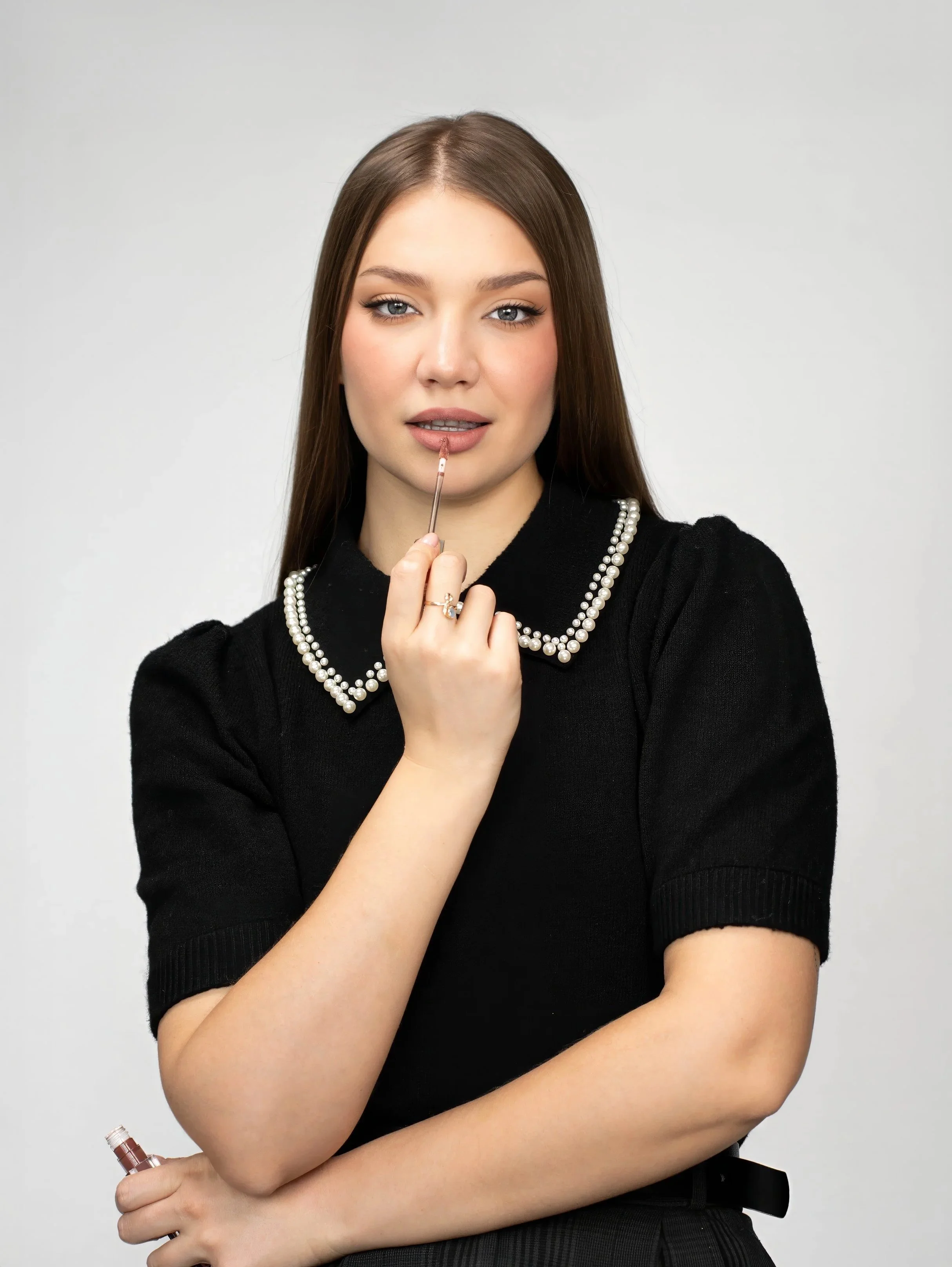 Toronto makeup artist branding photo of Masha applying lip gloss in clean studio portrait, close-up beauty shot highlighting makeup skills and personal brand