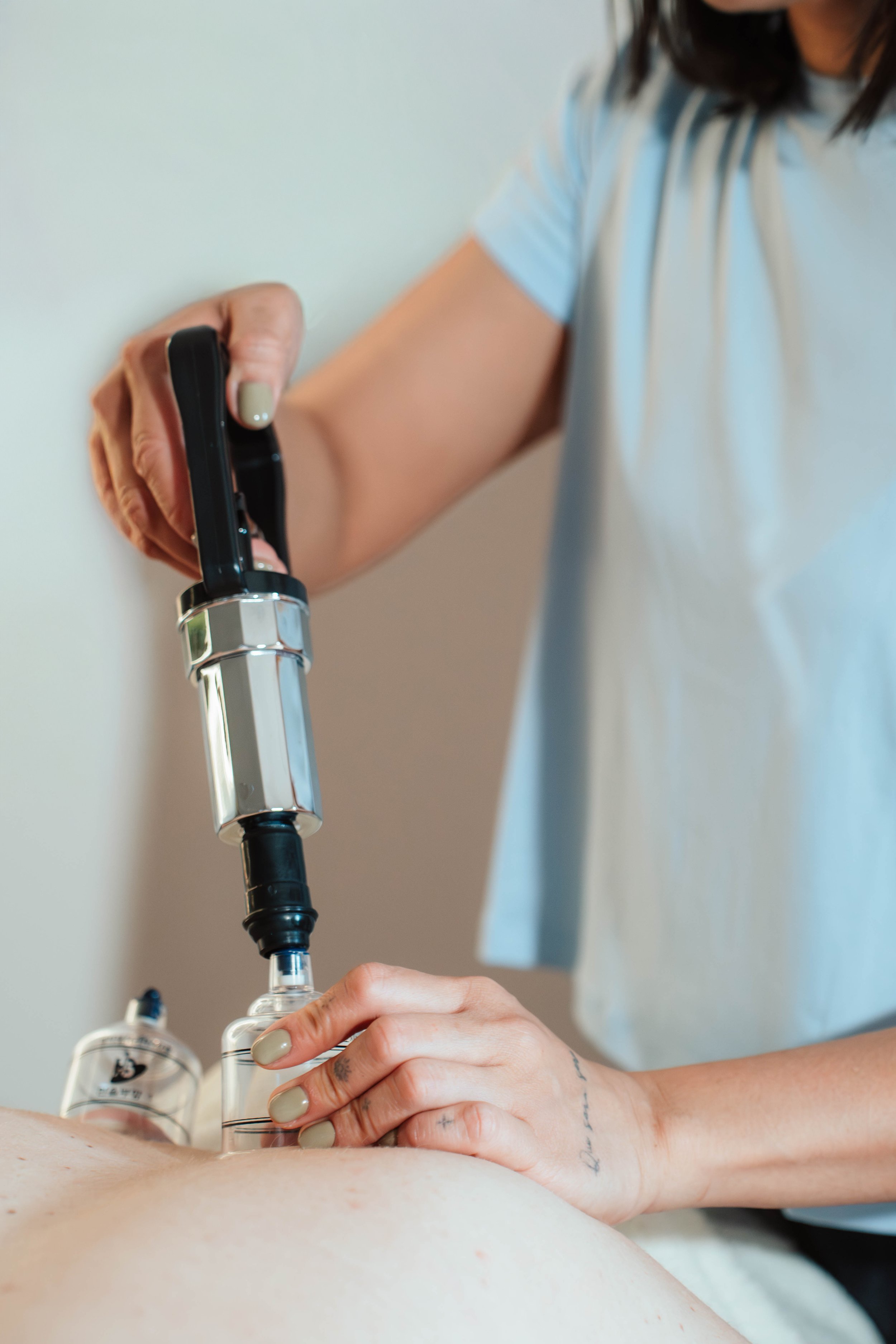 Close-up of a woman holding an ultrasound probe during a medical ultrasound examination on a patient's abdomen.