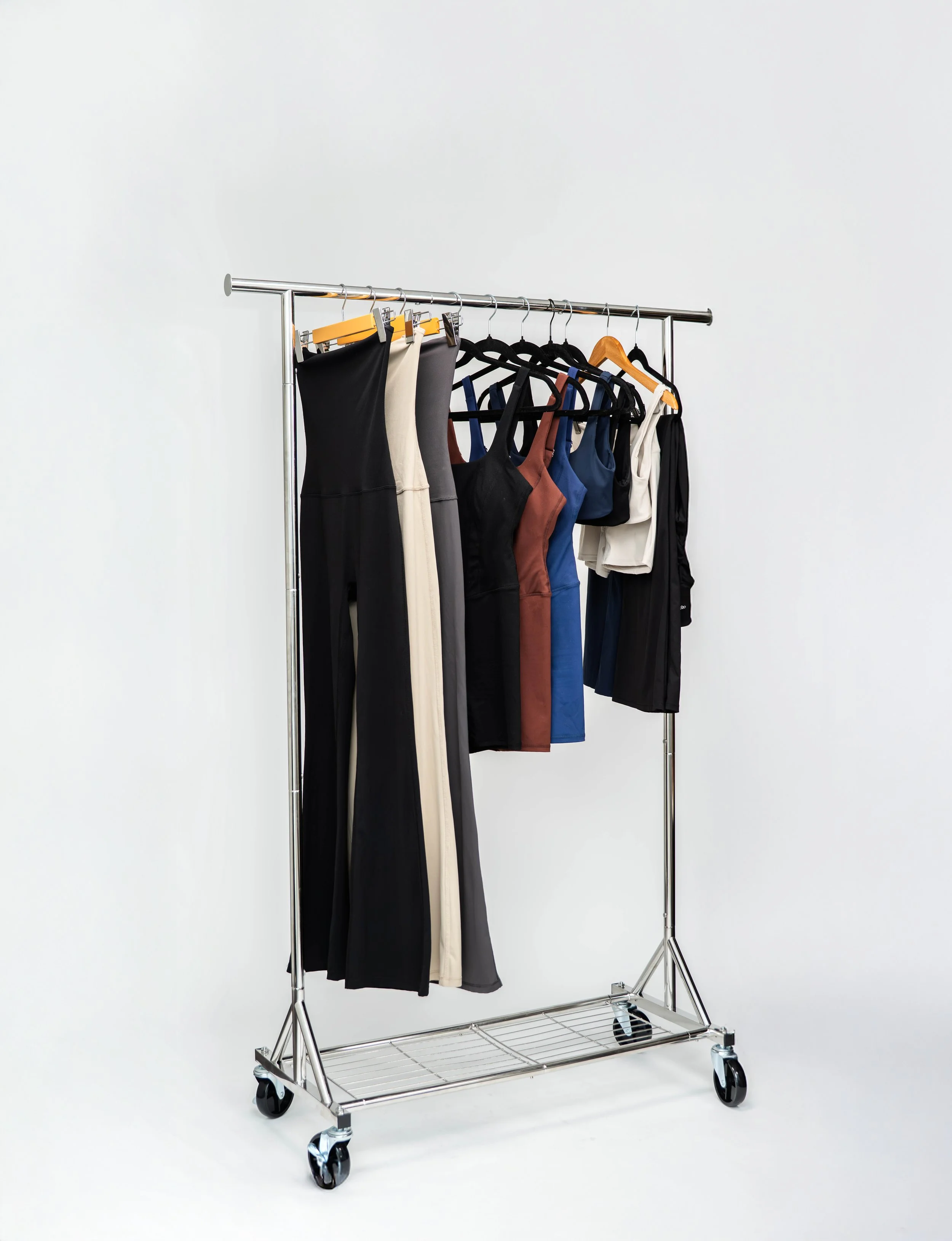 Clothing rack with various dresses and tops hanging on hangers.