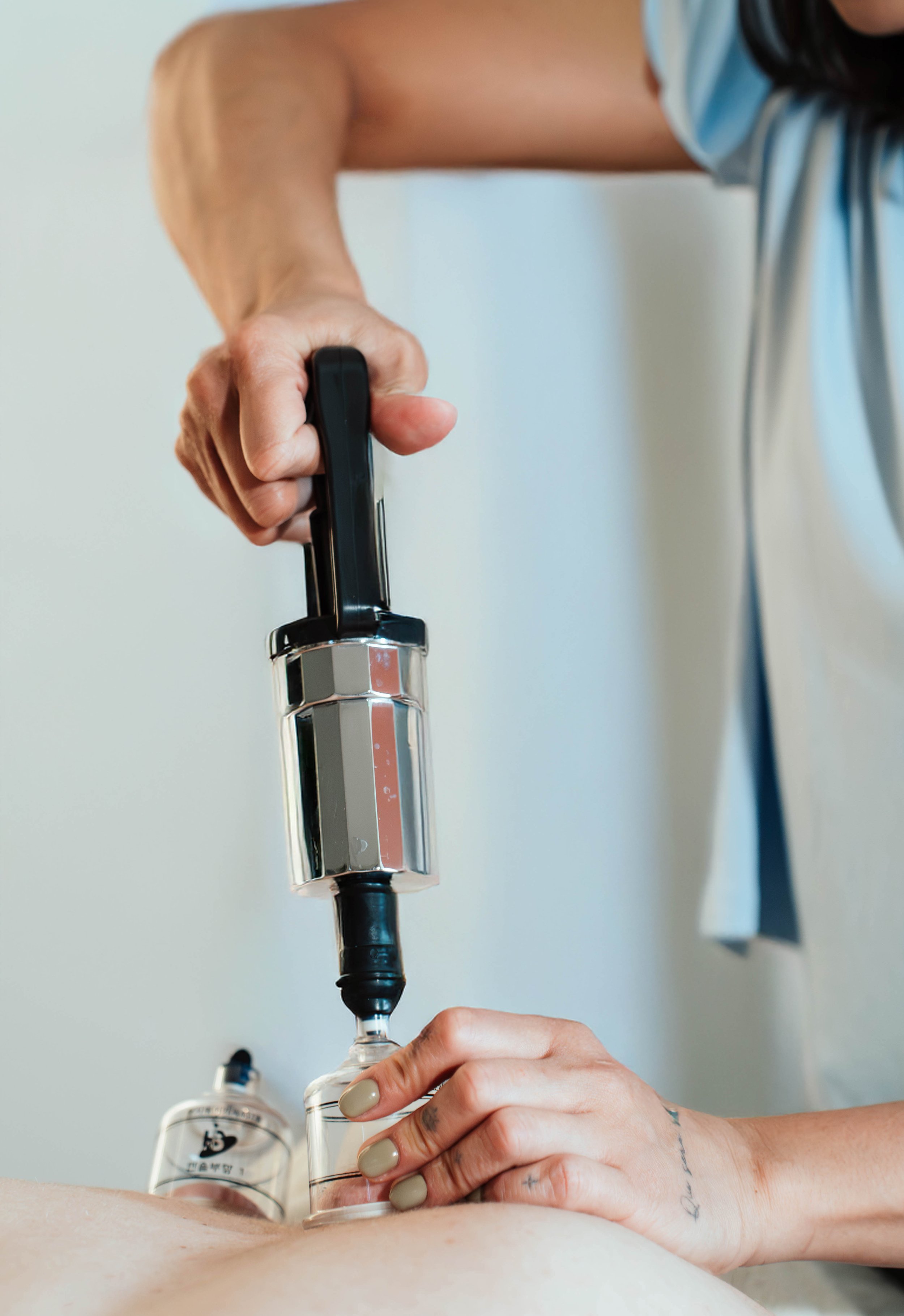 Close-up of a person using a medical syringe for injection into a patient's back.