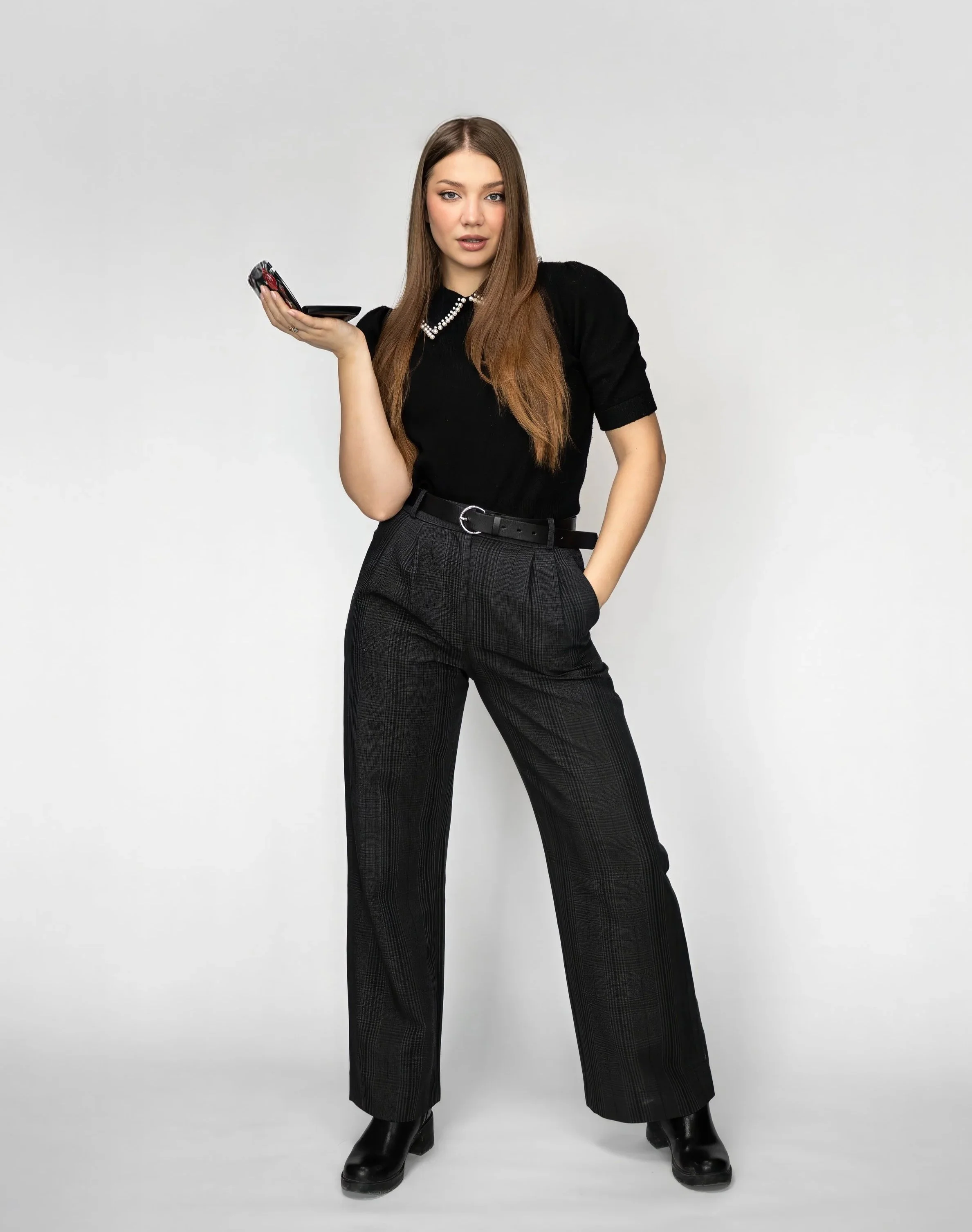 Toronto makeup artist branding photo of Masha standing in a clean studio holding makeup palette, full body editorial portrait showing personal brand and beauty work