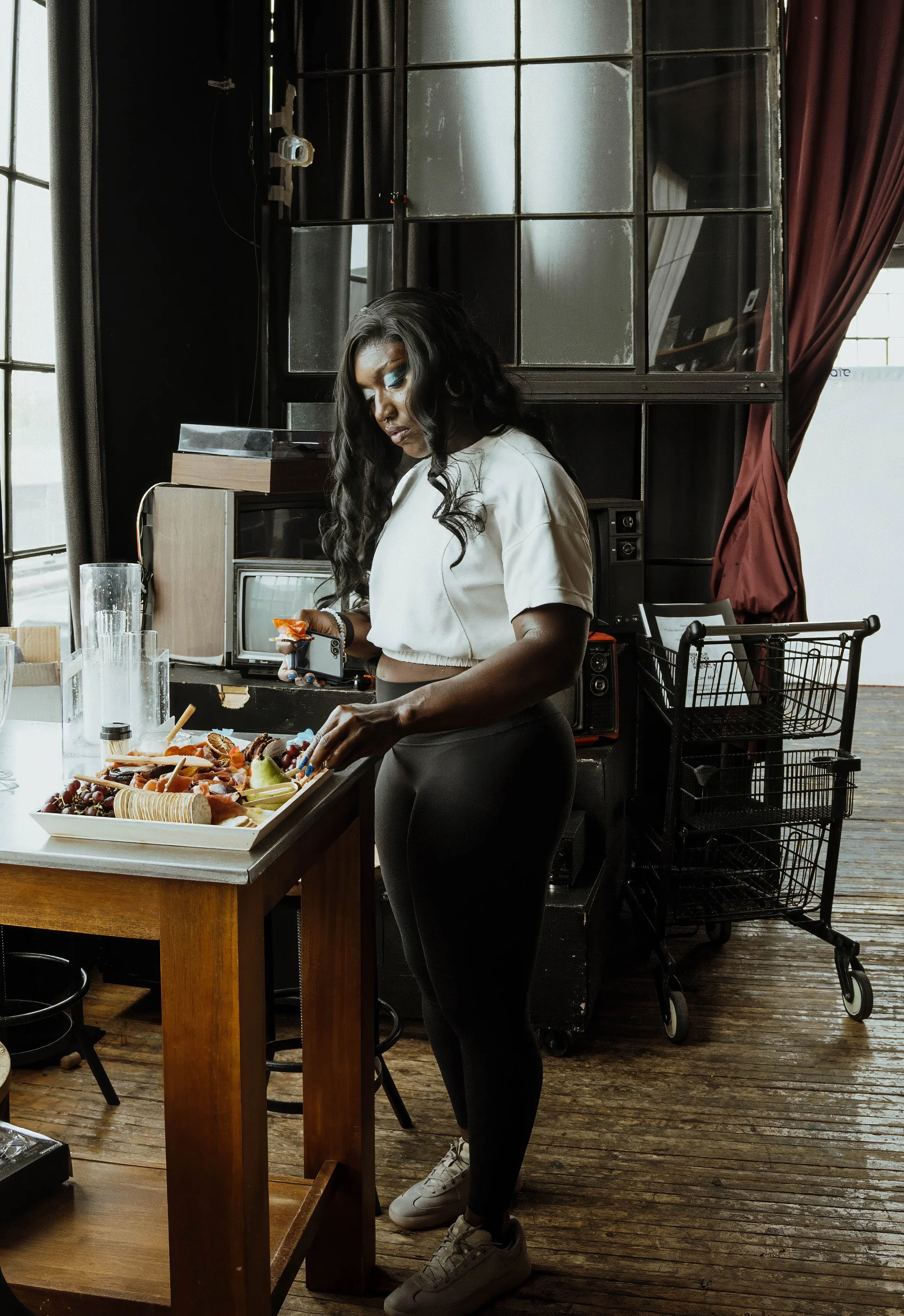 Canadian Olympian Cynthia Appiah enjoying a charcuterie spread behind the scenes during Lara Grace Creative Studio’s Olympic athlete editorial photoshoot at OBJX Studio in Toronto.