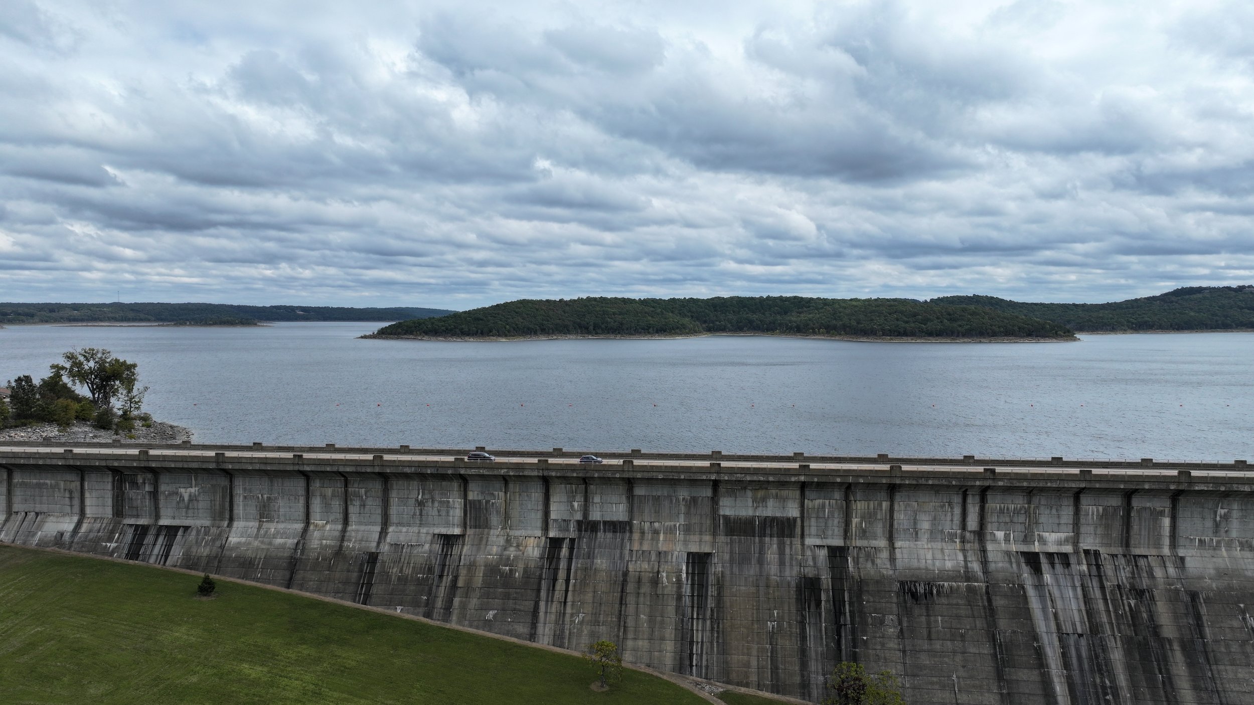 An aerial view of a majestic dam, showcasing its impressive structure and the powerful flow of water, a testament to human engineering amidst natural landscapes.