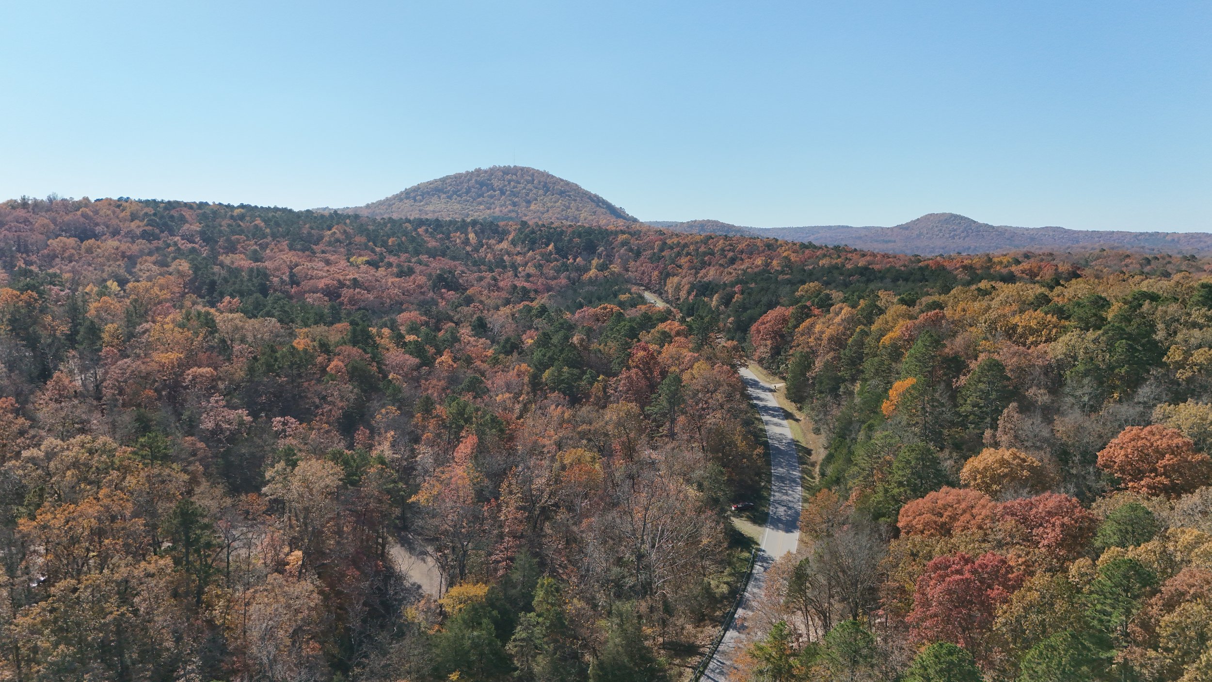 Aerial view of a national forest adorned in vibrant autumn colors, showcasing the seasonal beauty of changing foliage.