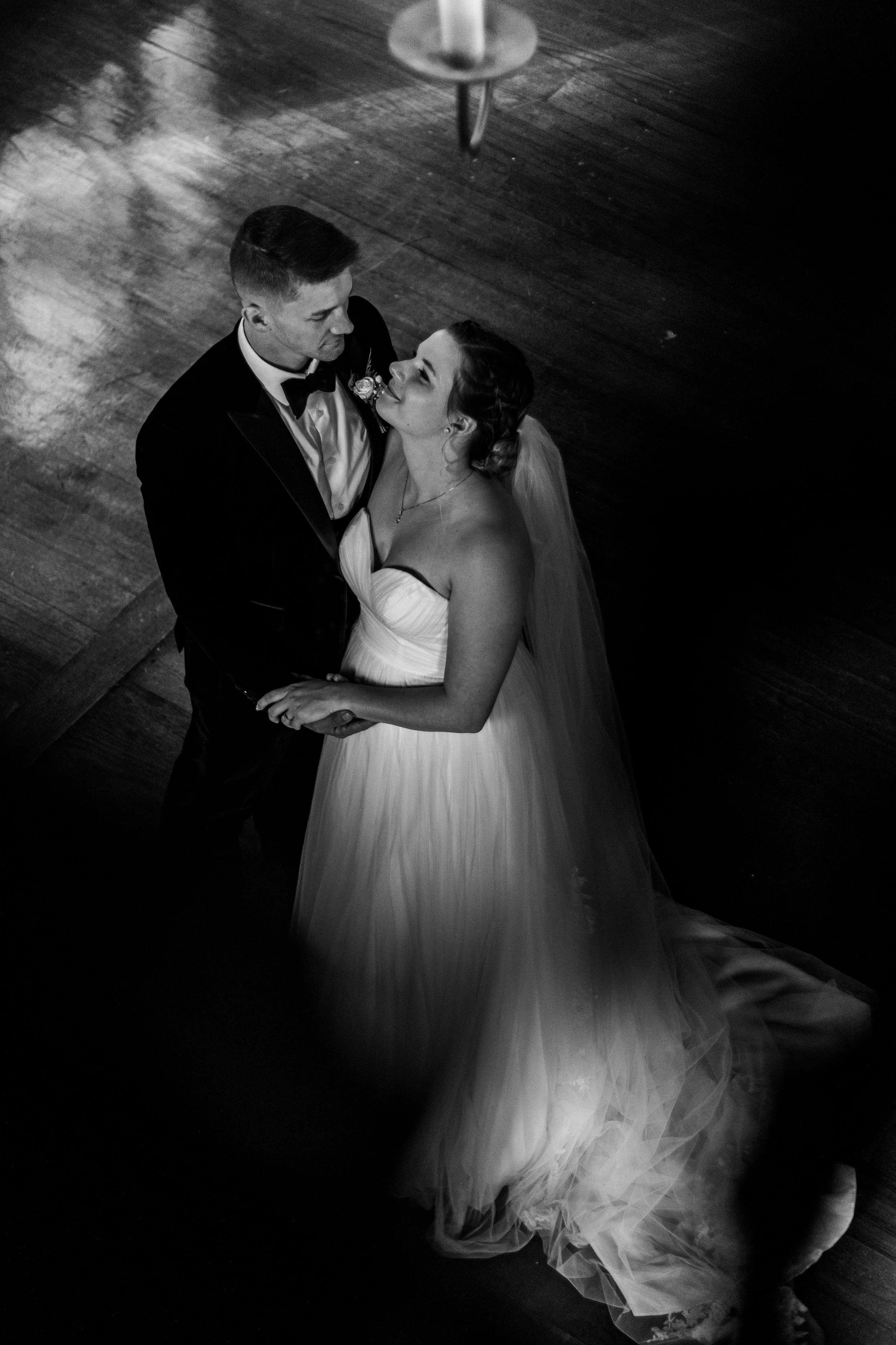 Black and white photo of a bride and groom dancing, looking into each other's eyes.