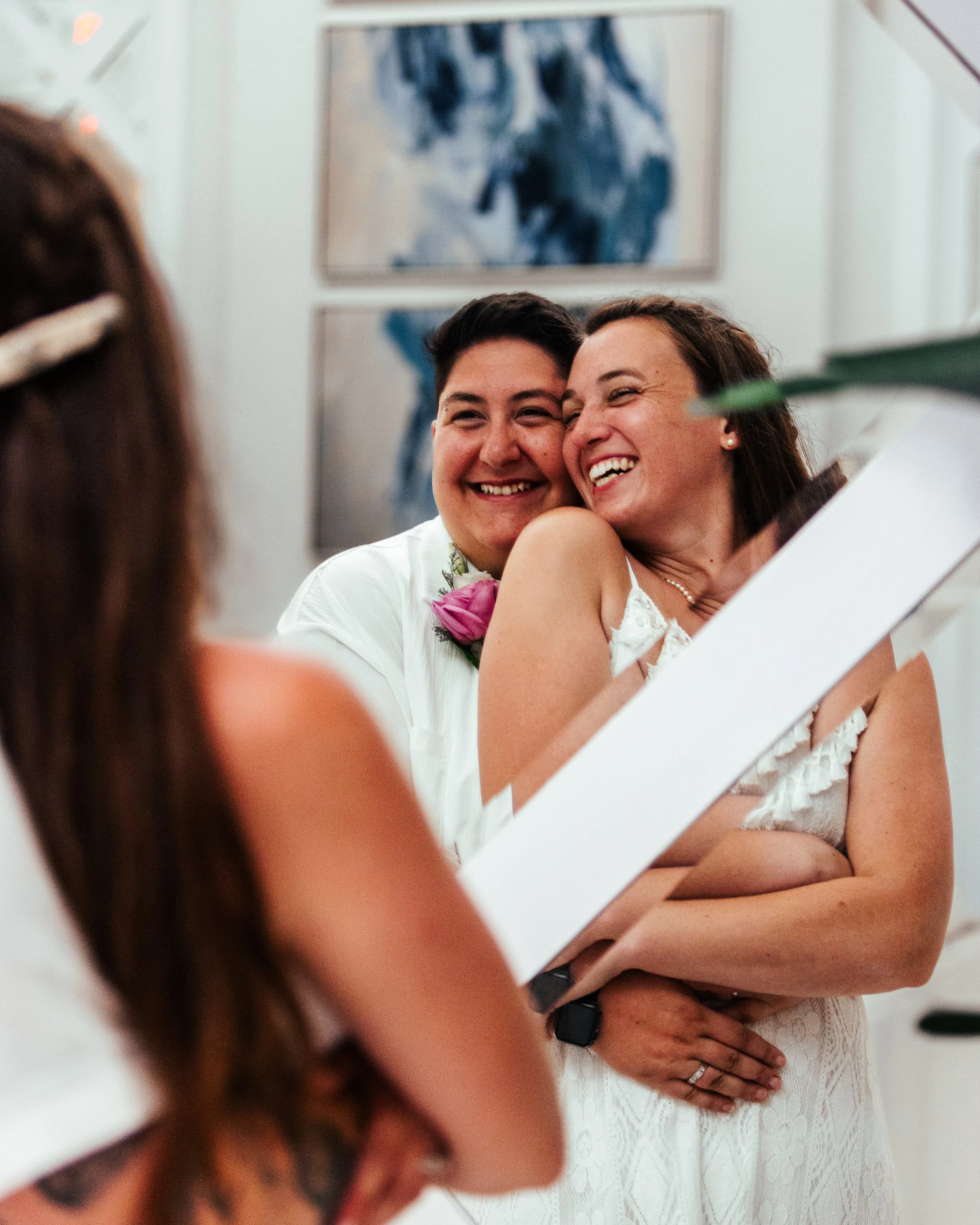 A couple at a wedding being tied the knot, smiling and embracing each other.