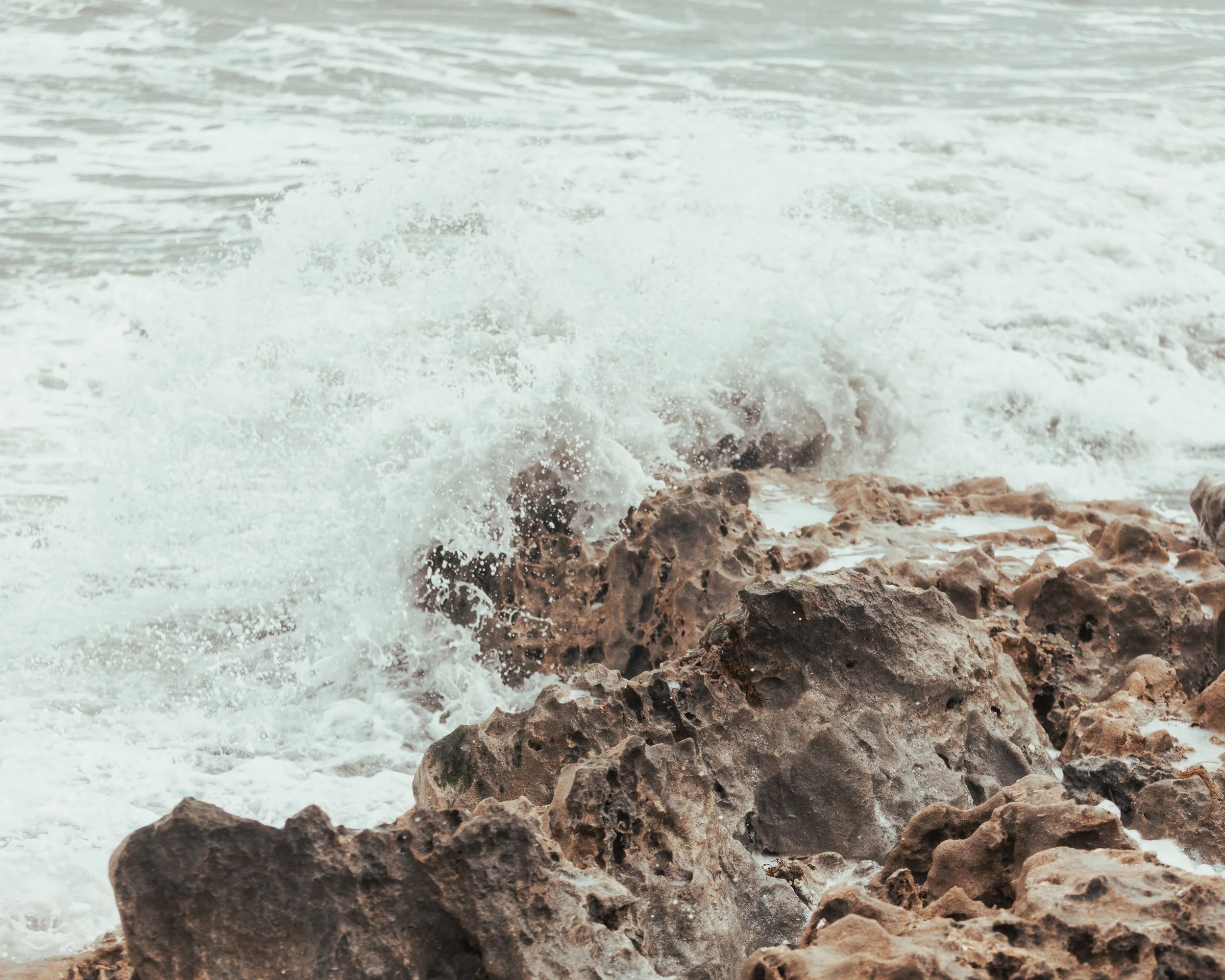Waves crashing against rocks on the shore.