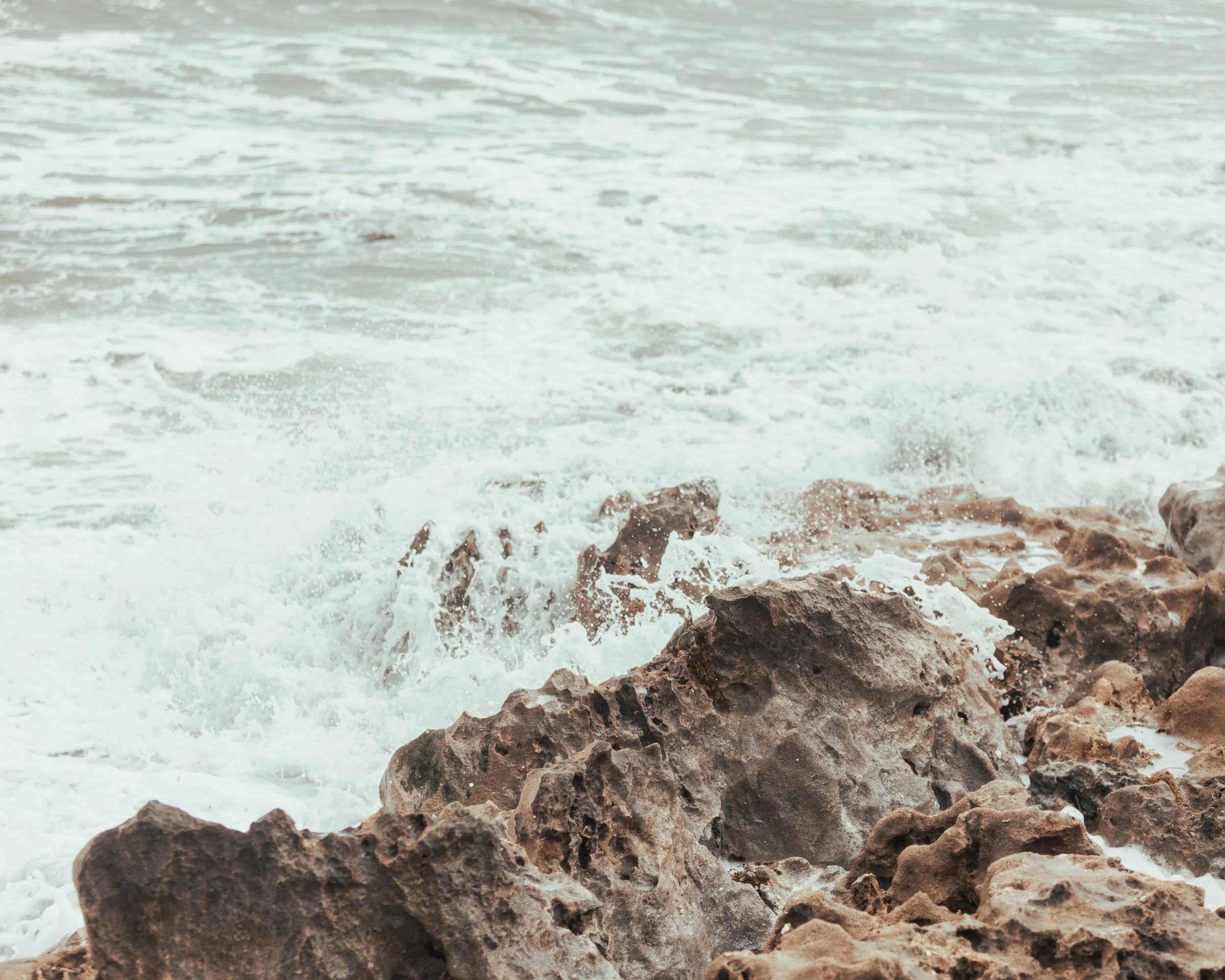 Waves crashing against rocks on a beach.