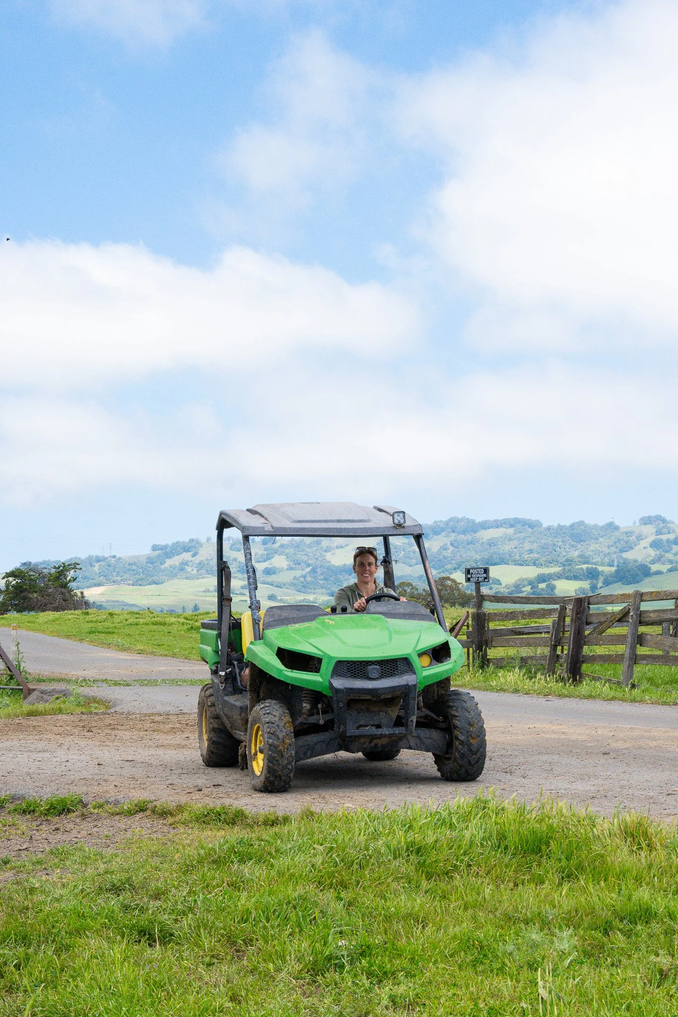 A woman drives a cart on a farm