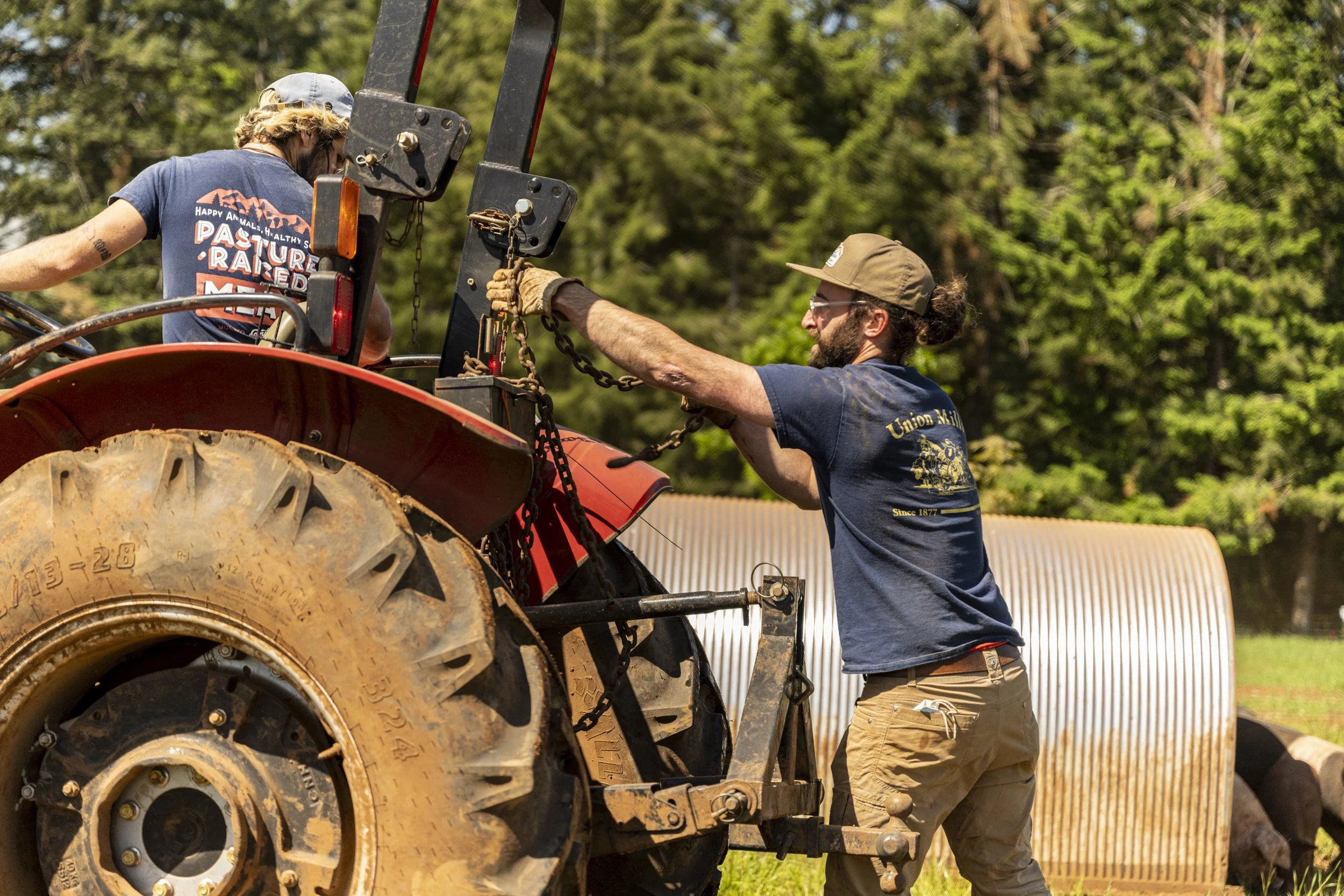 Two farmers work with a tractor