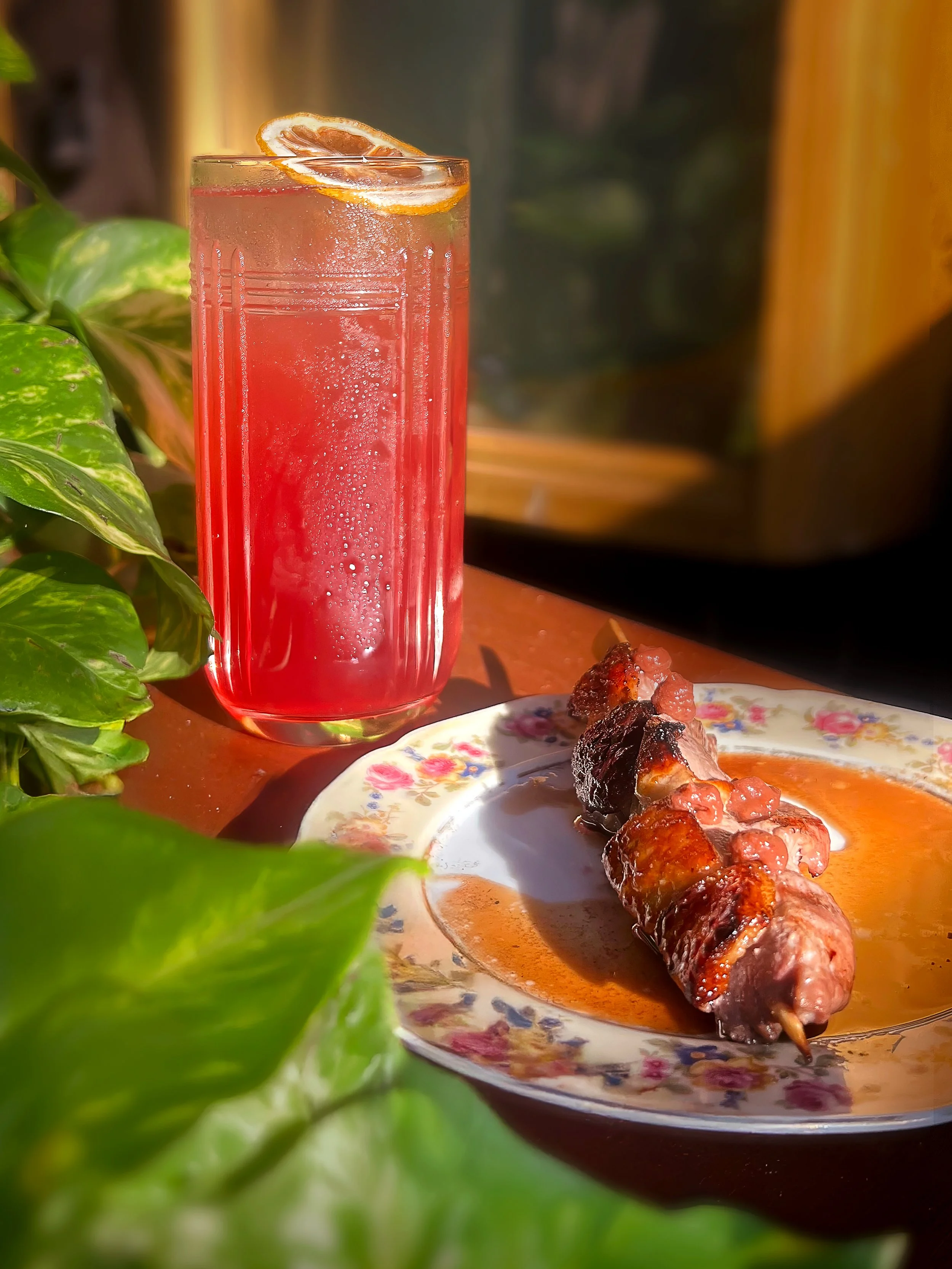 A Sonder cocktail with a beef skewer