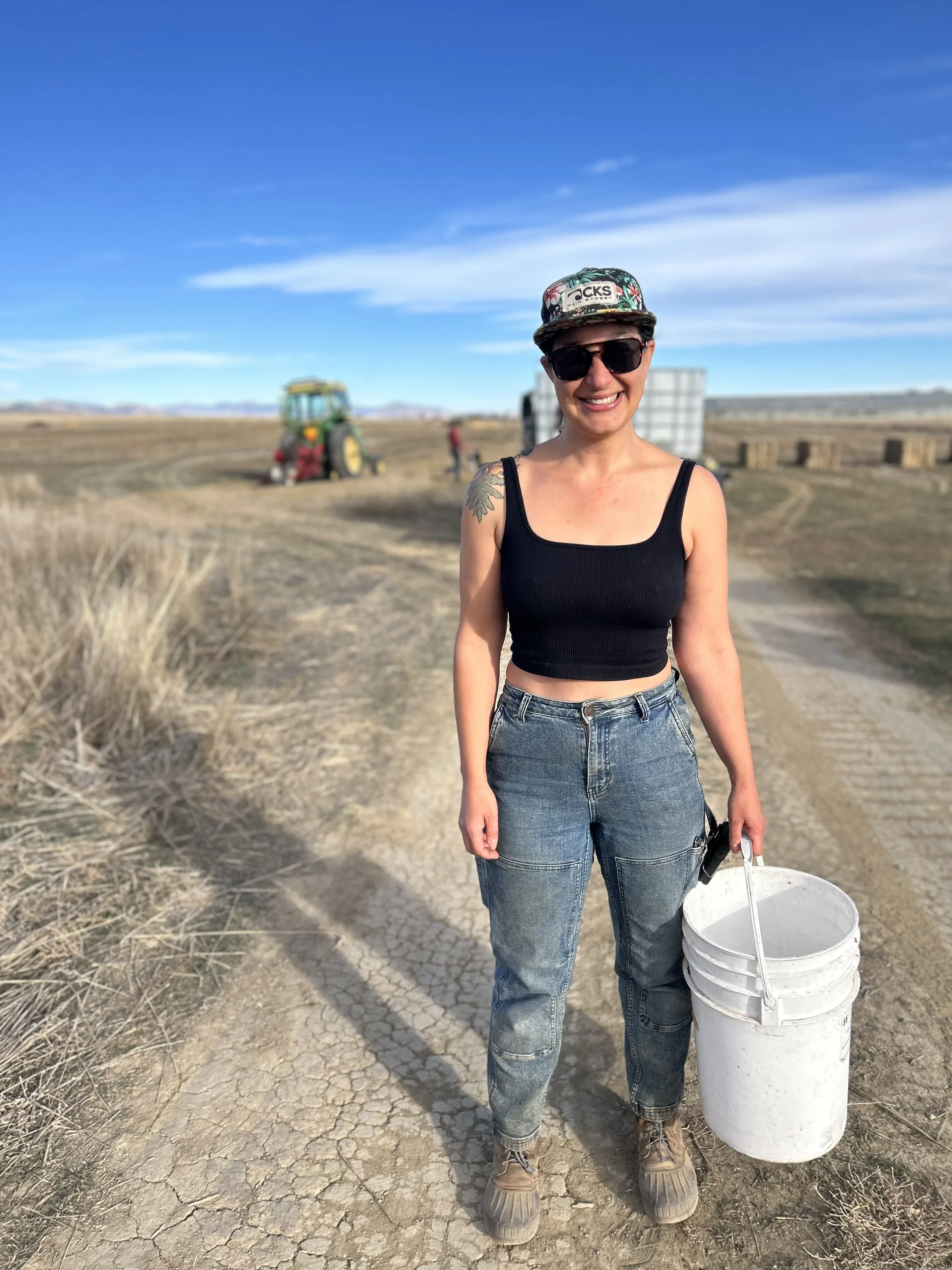 Farmer stands with bucket