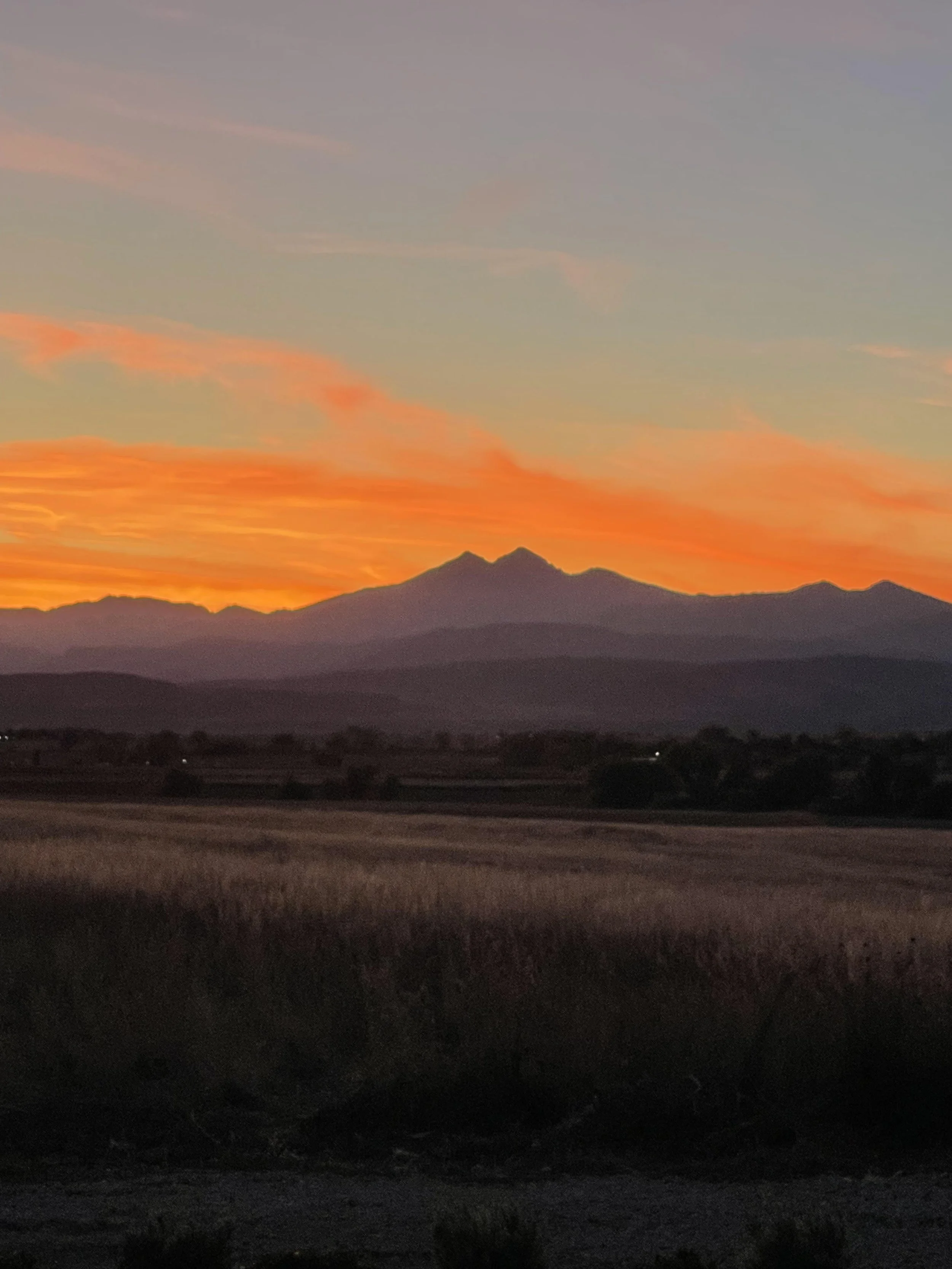 A sunset over a farm field