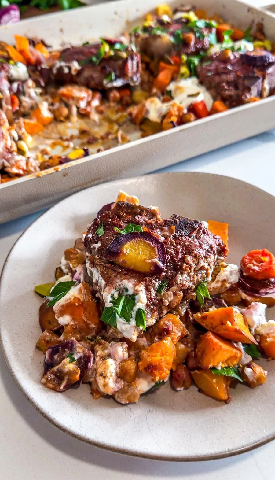 lamb loin chops / lamb loin chops recipe - portion of lamb, veggies, and sauce on a plate garnished with herbs