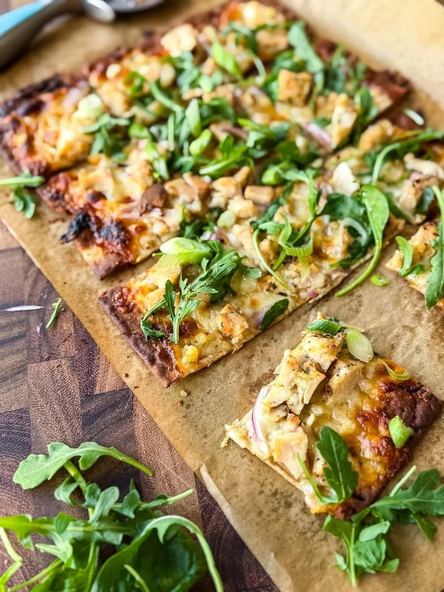 flatbread recipes // overhead hot of hot honey chicken flatbread with arugula and green onions