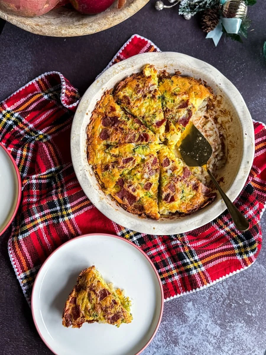 overhead photo of Christmas quiche with a slice on a plate next to it