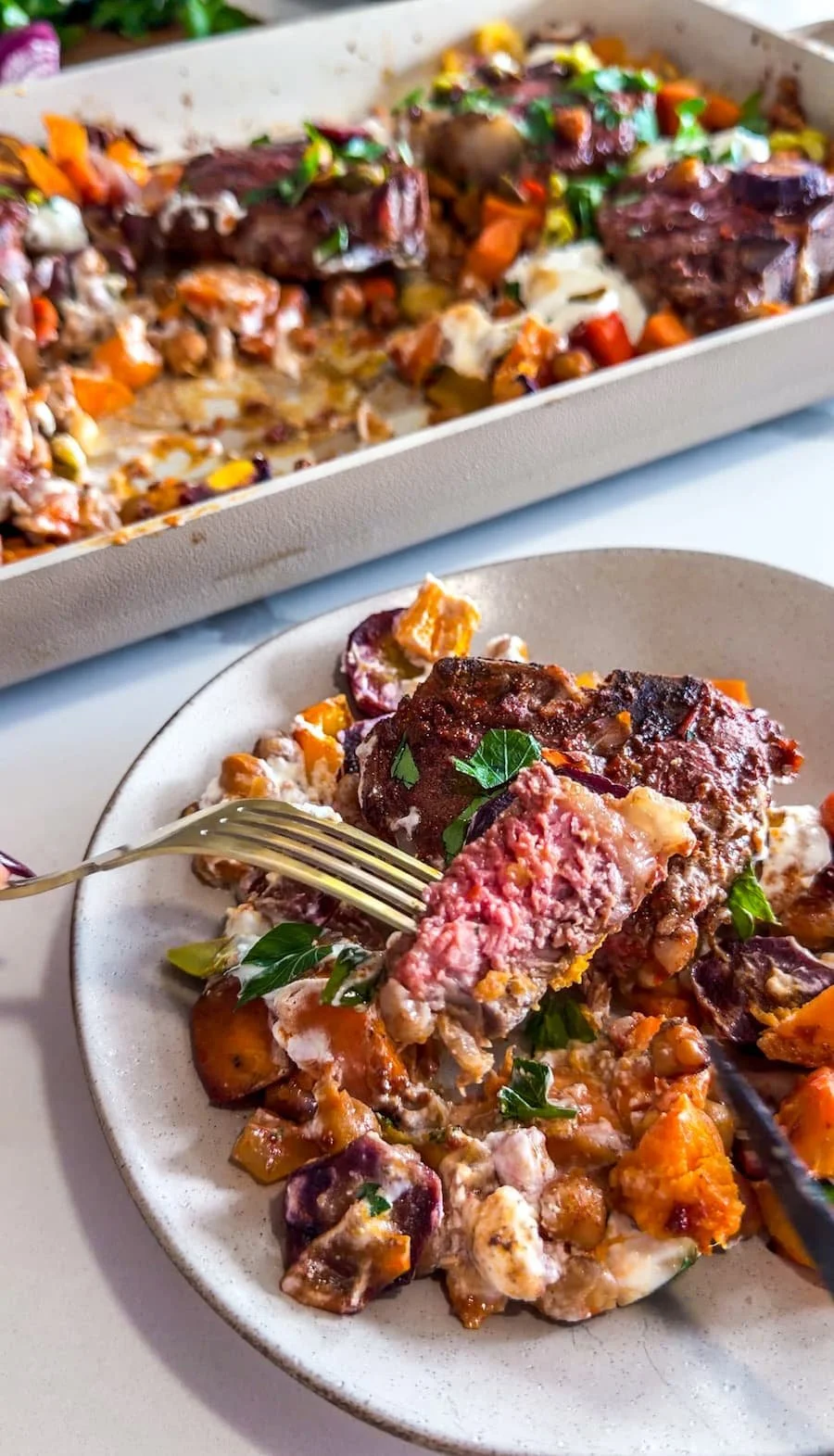 lamb loin chops / lamb loin chops recipe - portion of lamb and veggies and sauce on a plate with a piece of lamb sliced