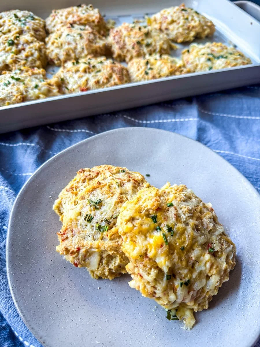 ground chicken recipes - breakfast biscuits on a plate with more on a sheet pan in the background