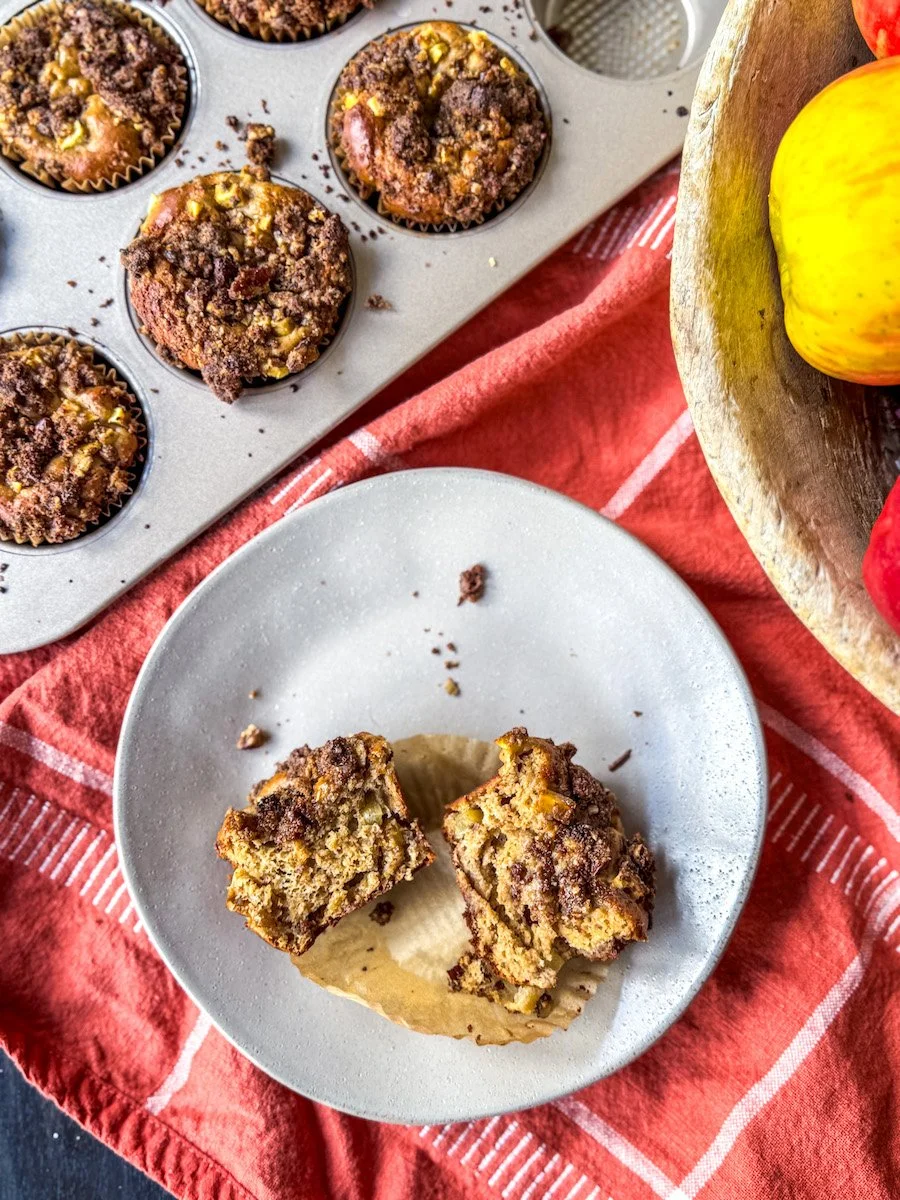 apple protein muffins with one split in half on a plate