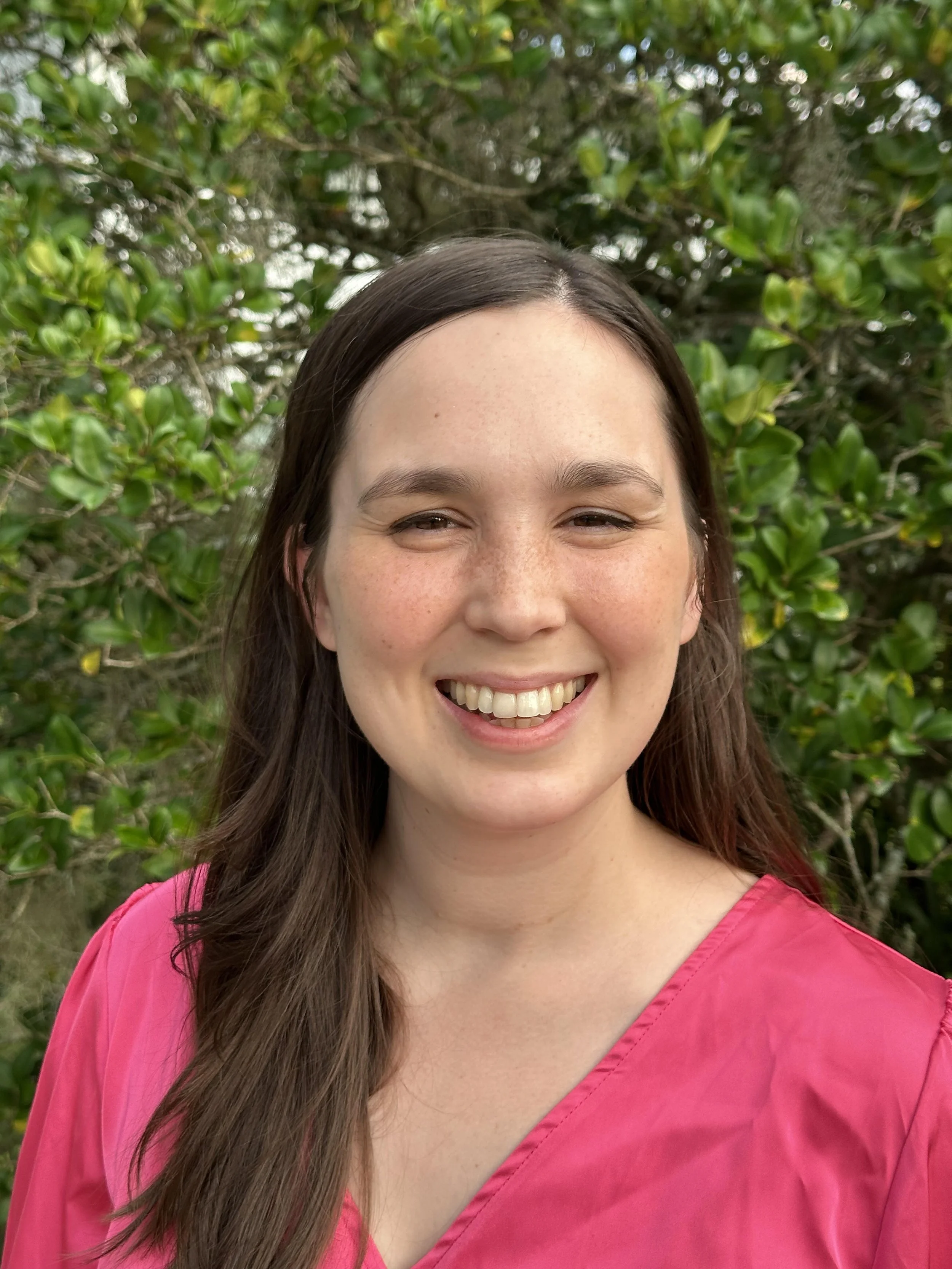 young, female therapist, warm smile, pink shirt