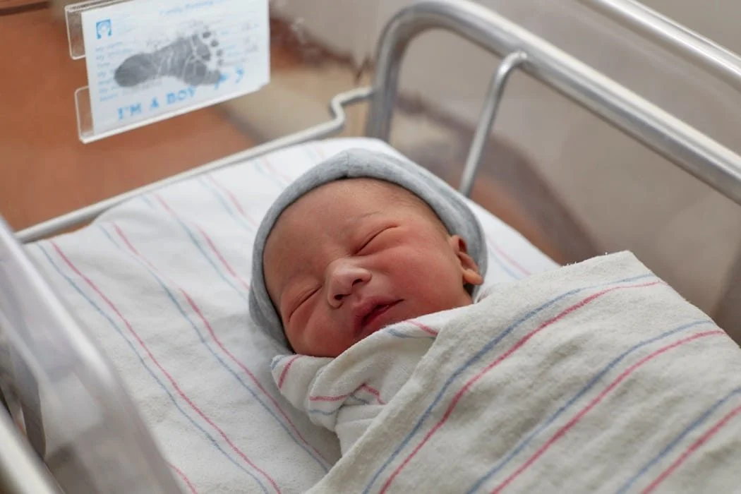 Newborn infant in a hospital crib