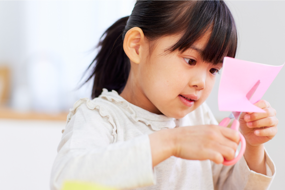Fine motor skills practice by cutting with scissors