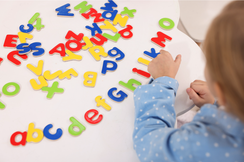 Kid pointing at letters of the alphabet
