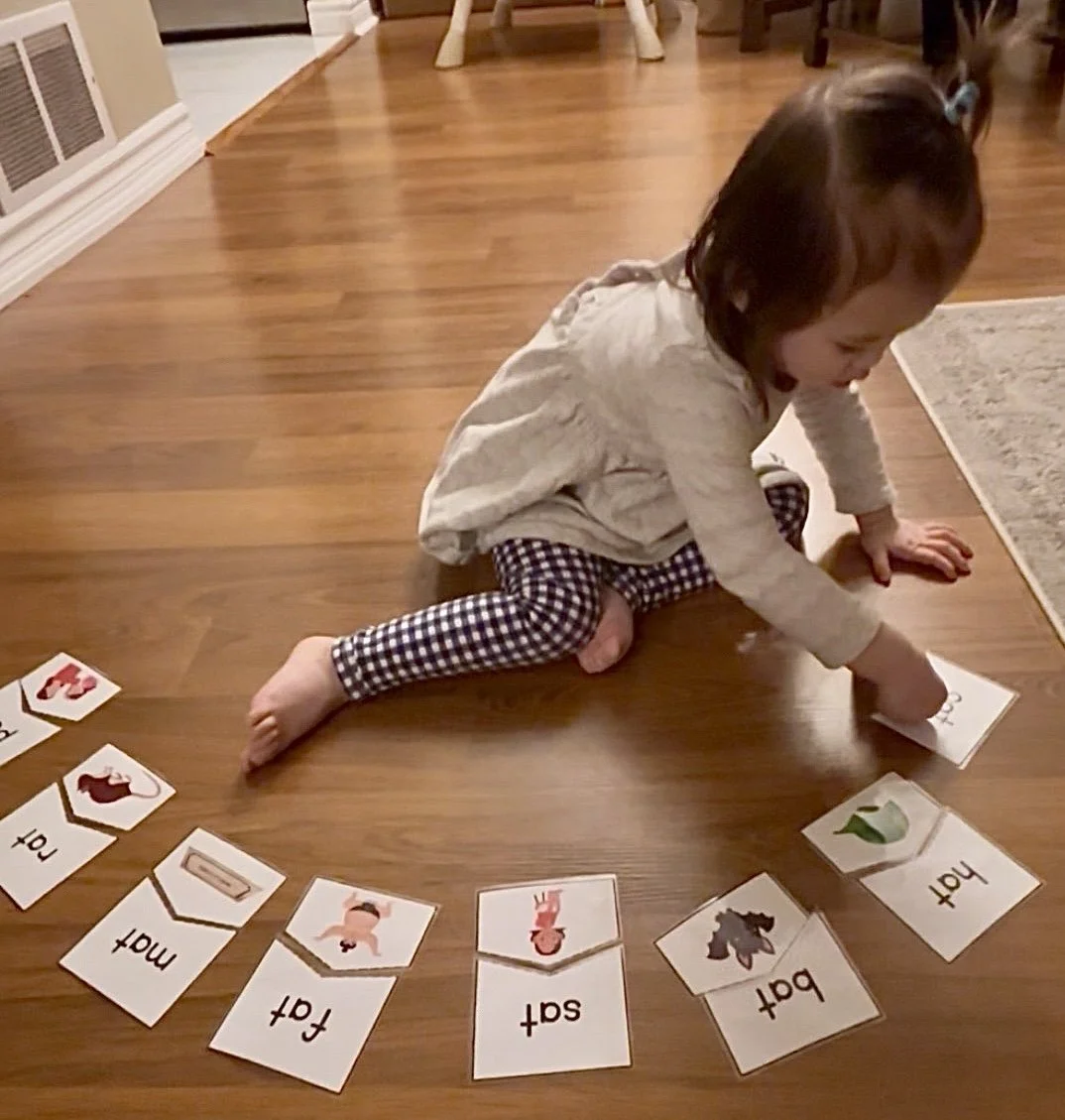This is a picture of a toddler matching a CVC word puzzle