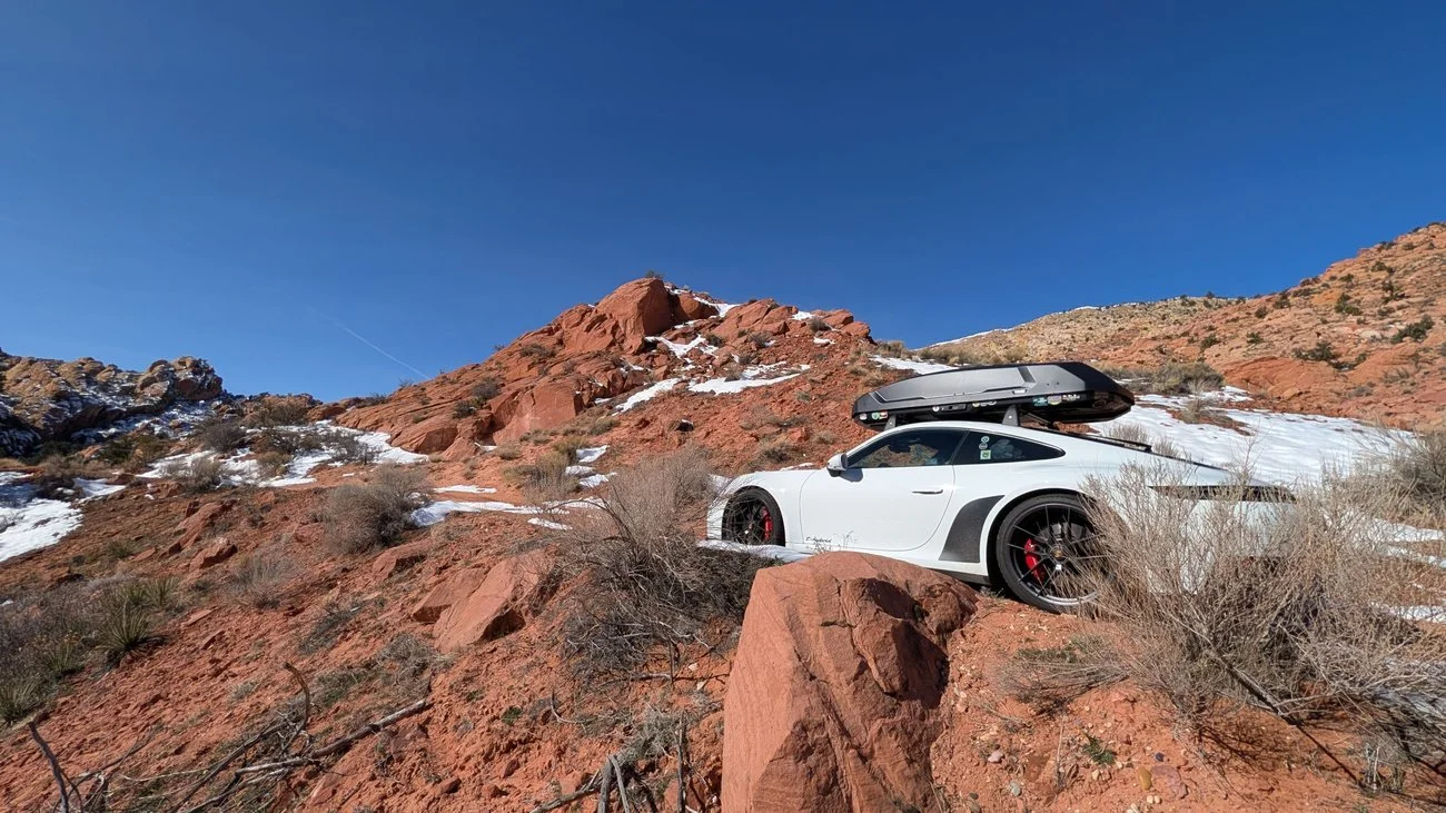 white-992-snowy-desert-road-black-stone-guards-orad-trip-side-view.jpg