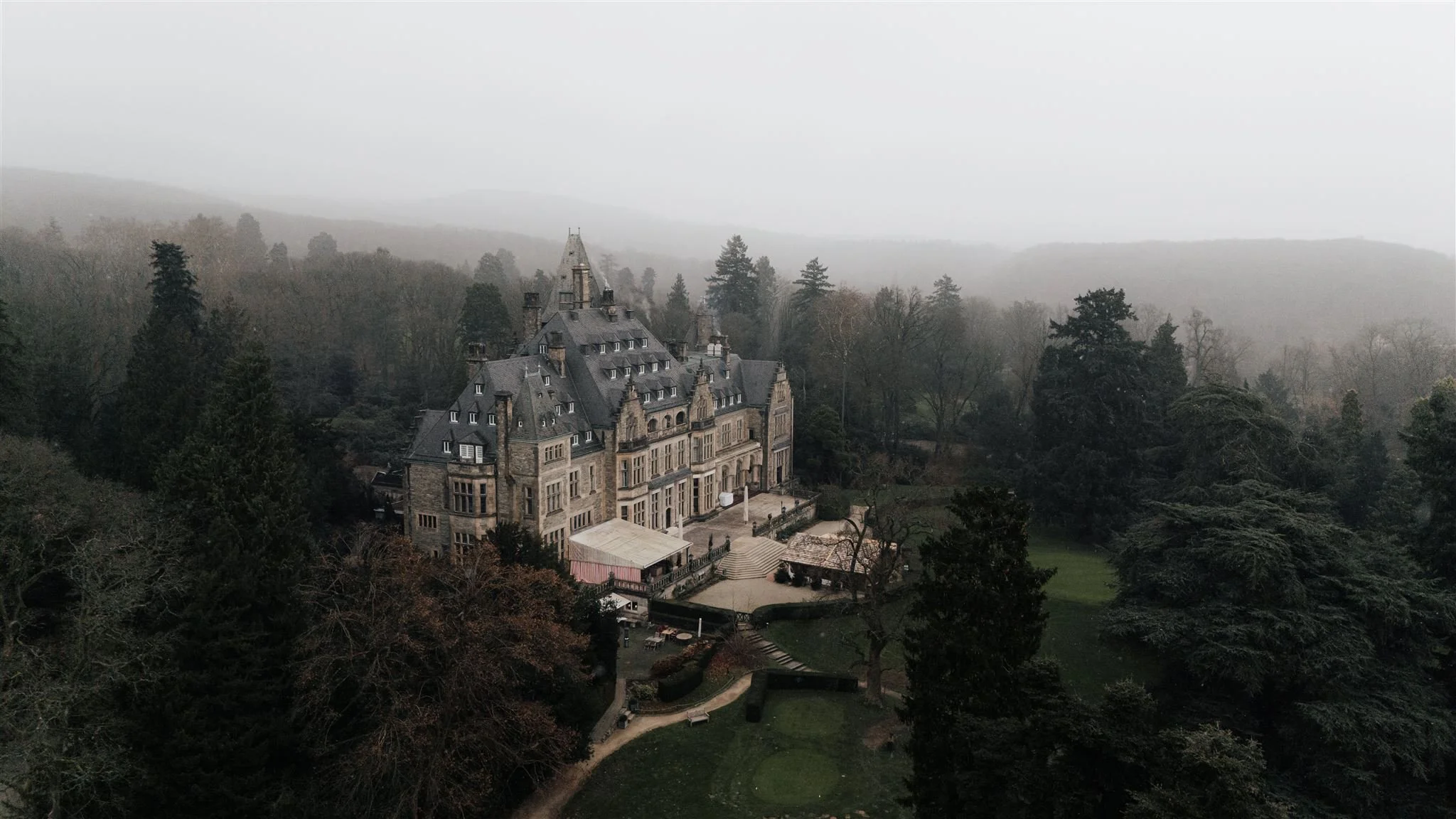 Drohnenaufnahme Schlosshotel Kronberg von Bäumen umgeben