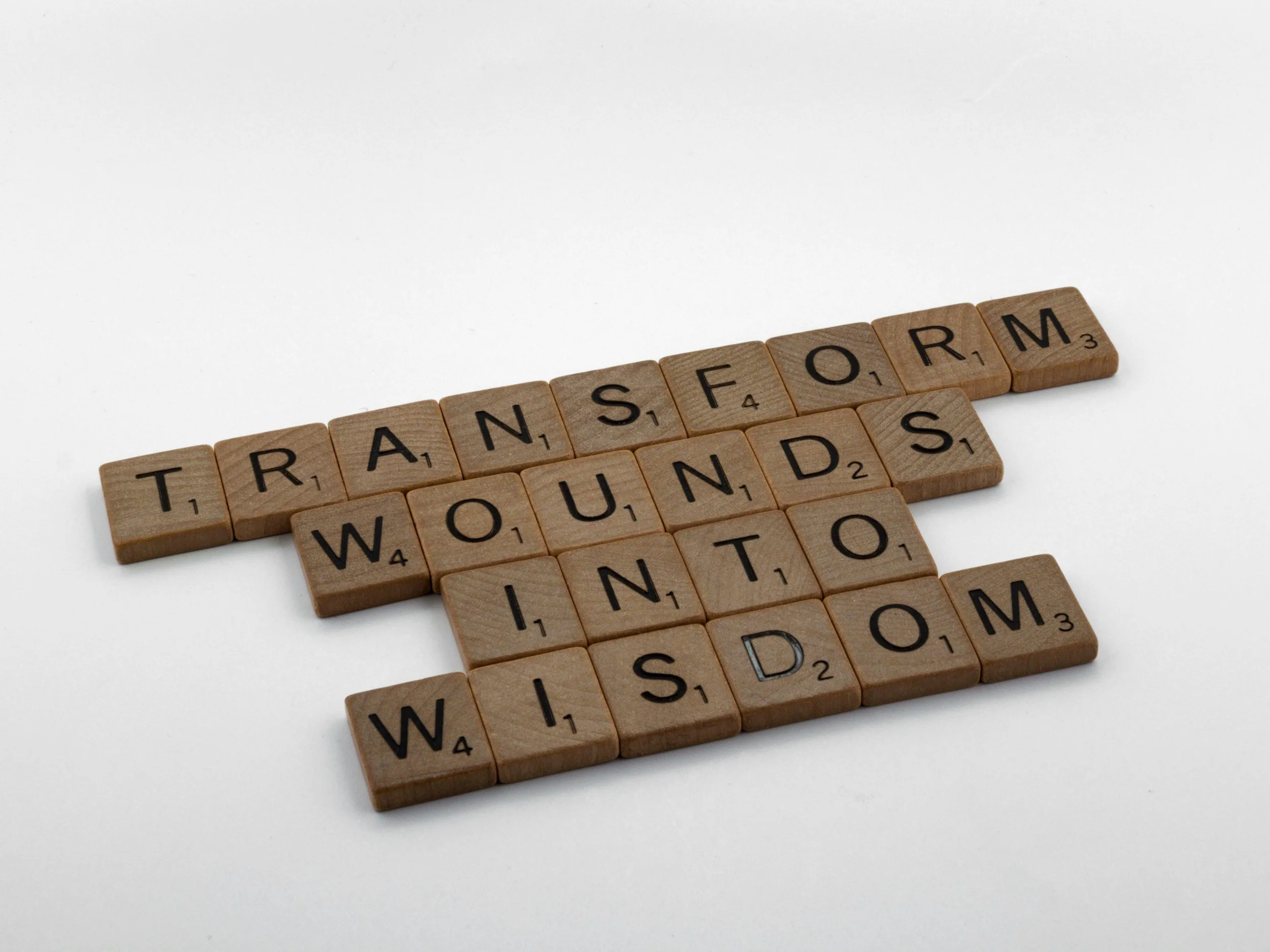 scramble tiles spelling out transform wounds into wisdom