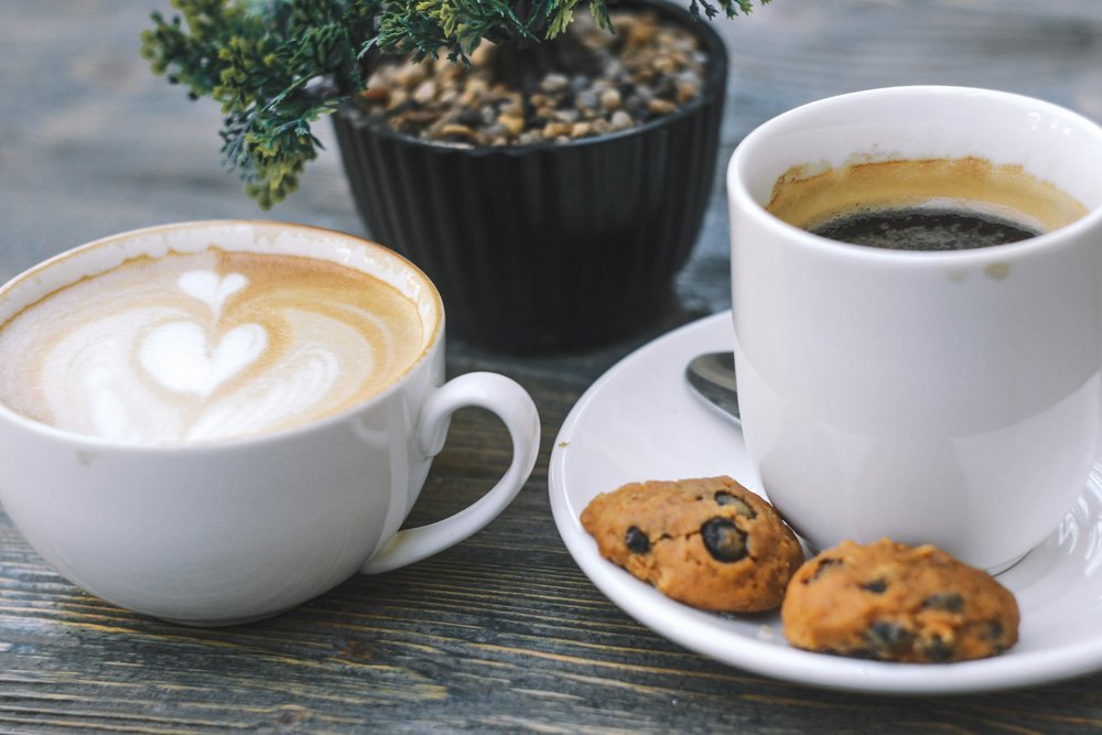 Kaffe og småkager til dessert - Kopper med friskbrygget kaffe, serveret med cookies, klar til at nydes af gæsterne.