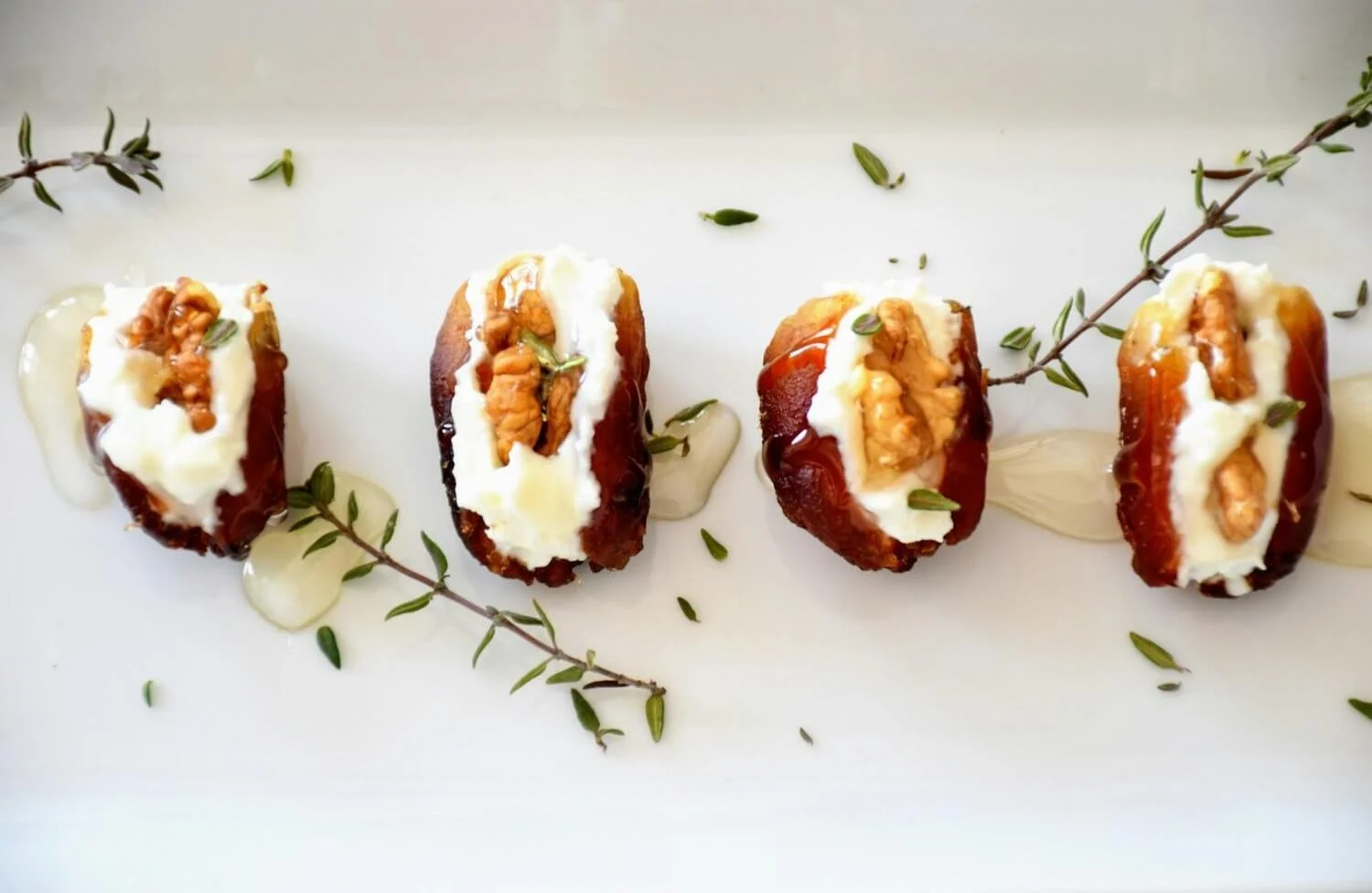 Delicious Canapés with Cheese and Herbs - Close-up of gourmet cheese-stuffed dates with herbs served as canapés.