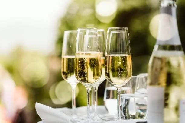 Champagneglas klar til fejring - Champagneglas og vandflaske på et festligt bord, klar til fejring.