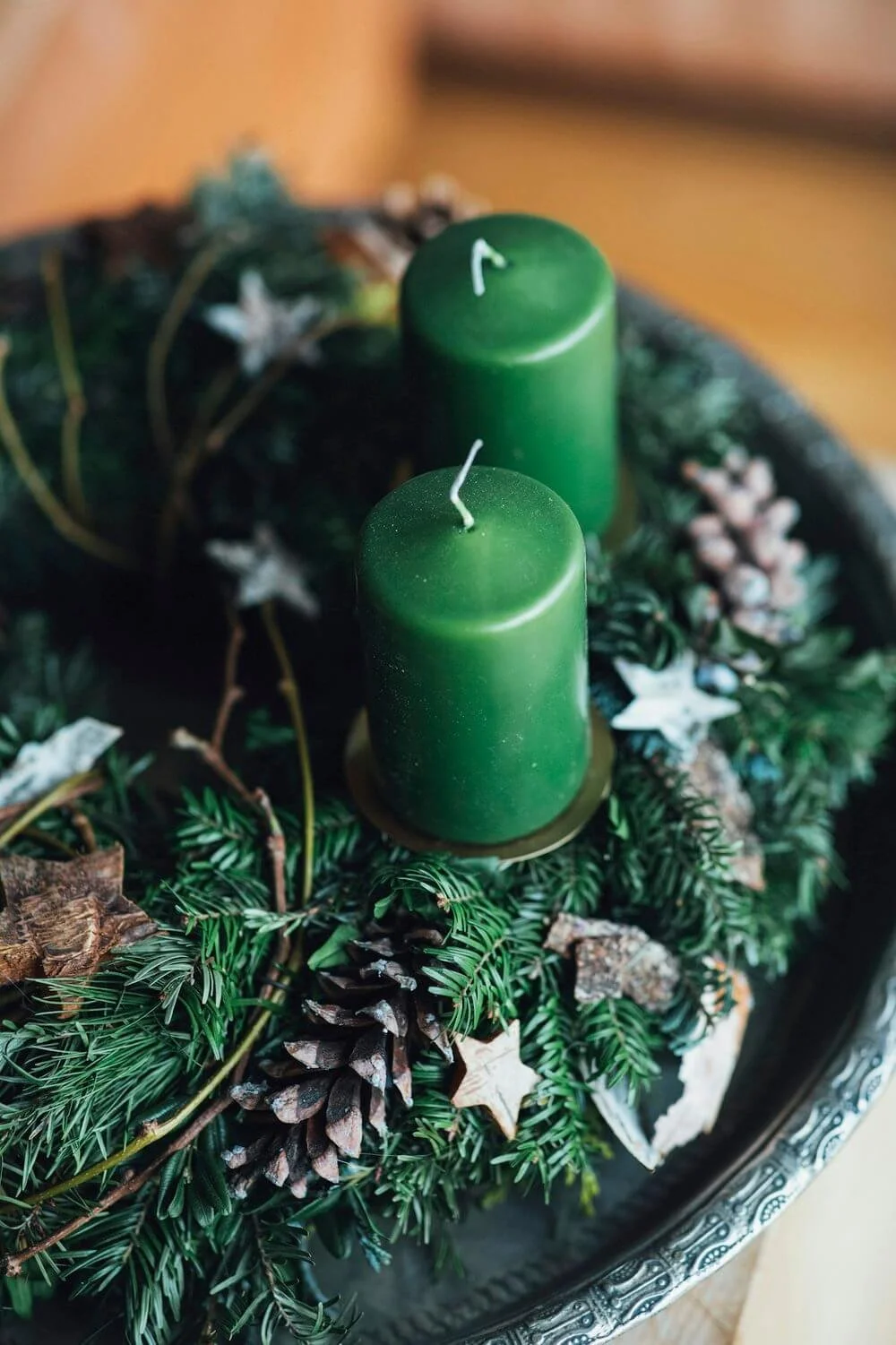 Grønne julelys på krans - Juledekoration med grønne stearinlys, fyrretræsgrene og kogler.