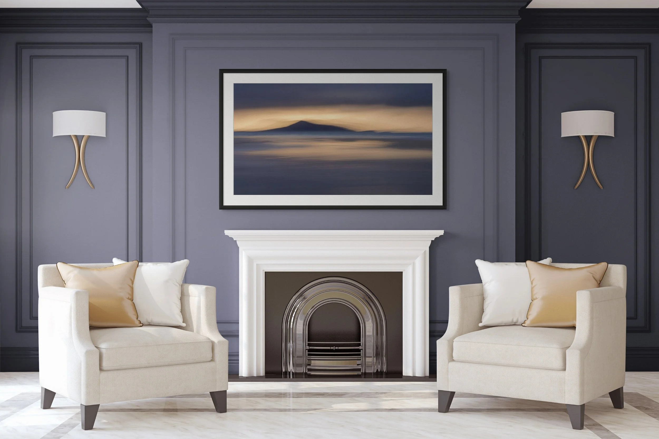 Living room with two cream armchairs with pillows, white fireplace, dark blue wall with wood paneling, framed landscape painting of a mountain and water, and two wall-mounted lamps.