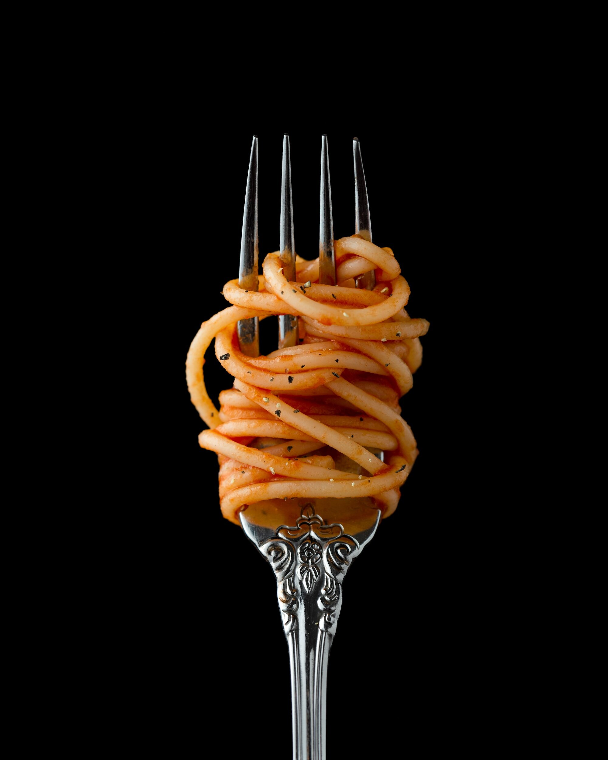 La simplicidad y elegancia de los spaghetti al pomodoro son inmortalizados en esta toma, donde cada hebra está perfectamente cubierta de salsa, creando una imagen tan apetecible como clásica.