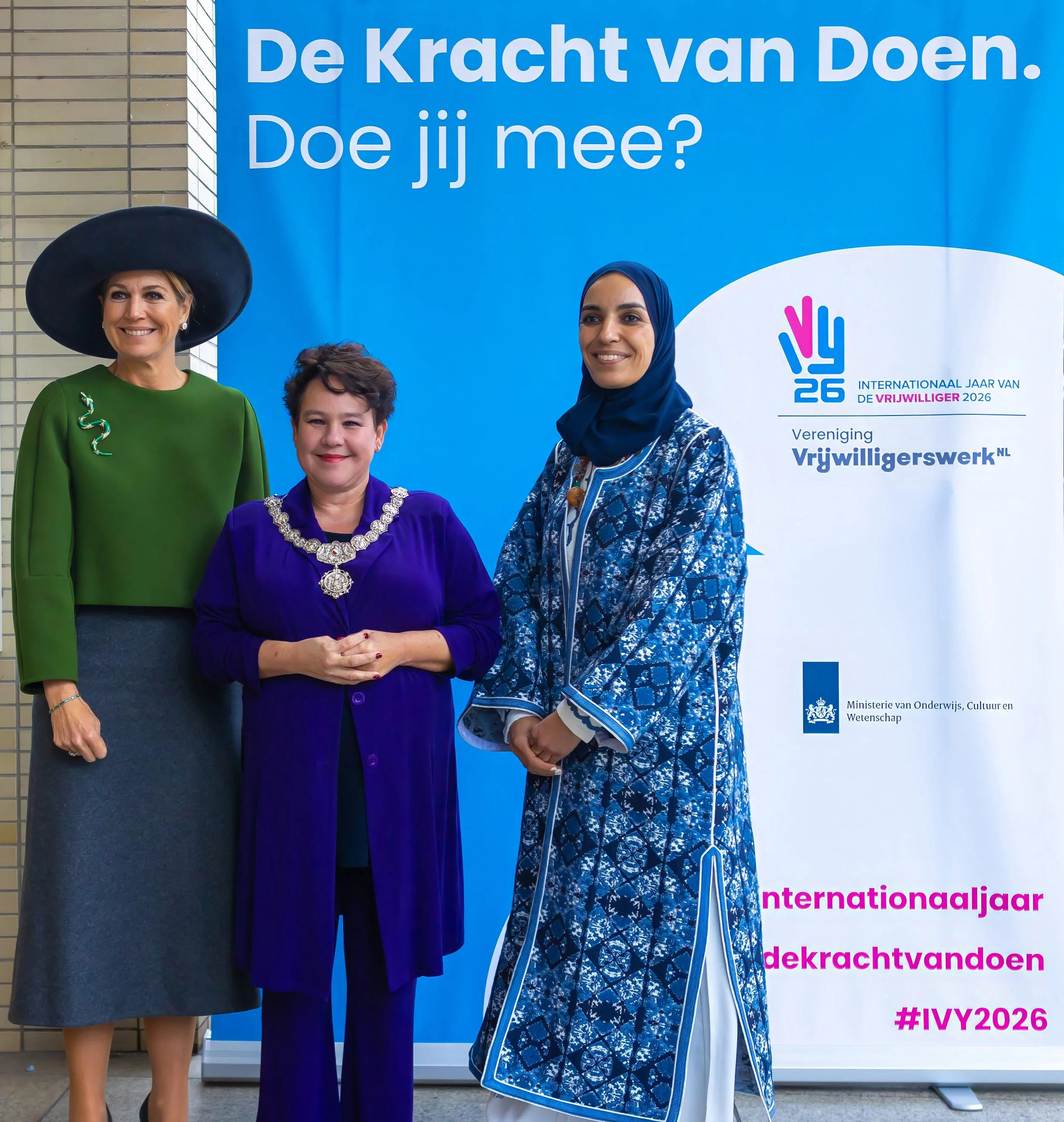 Koningin Maxima, Burgemeester van Utrecht Sharon Dijksma en directrice VrijwilligerswerkNL Laila voor een banner van het Internationaal Jaar van de Vrijwilliger 2026 in Utrecht