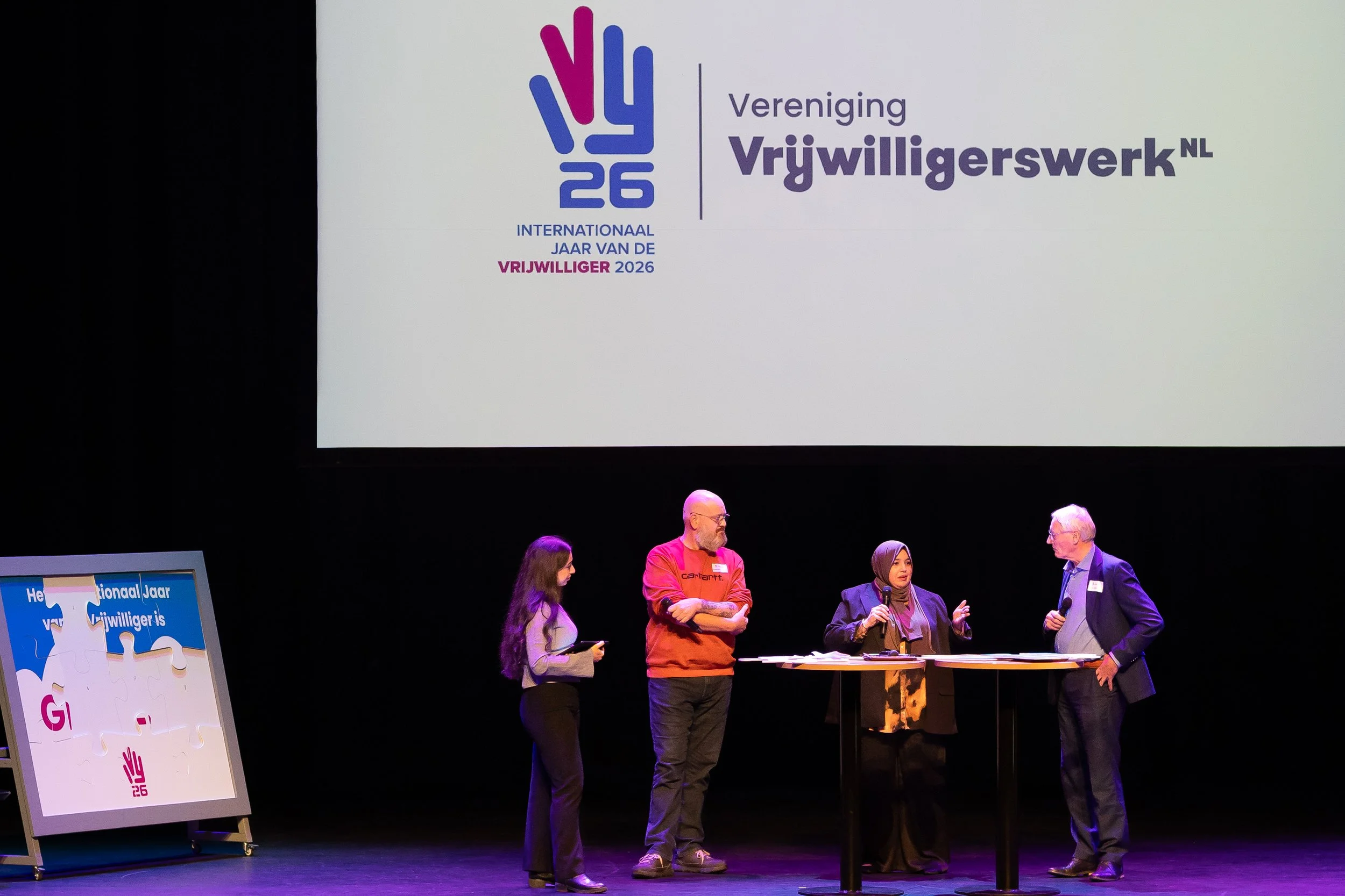 Tafelgesprek op het podium tussen vier vrijwilligers tijdens de opening van het Internationaal Jaar van de Vrijwilliger 2026