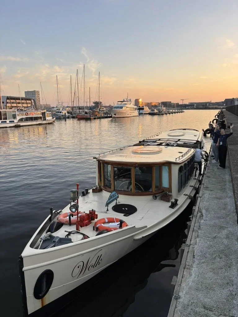 salonboot in de amsterdamse grachten met zonsondergang