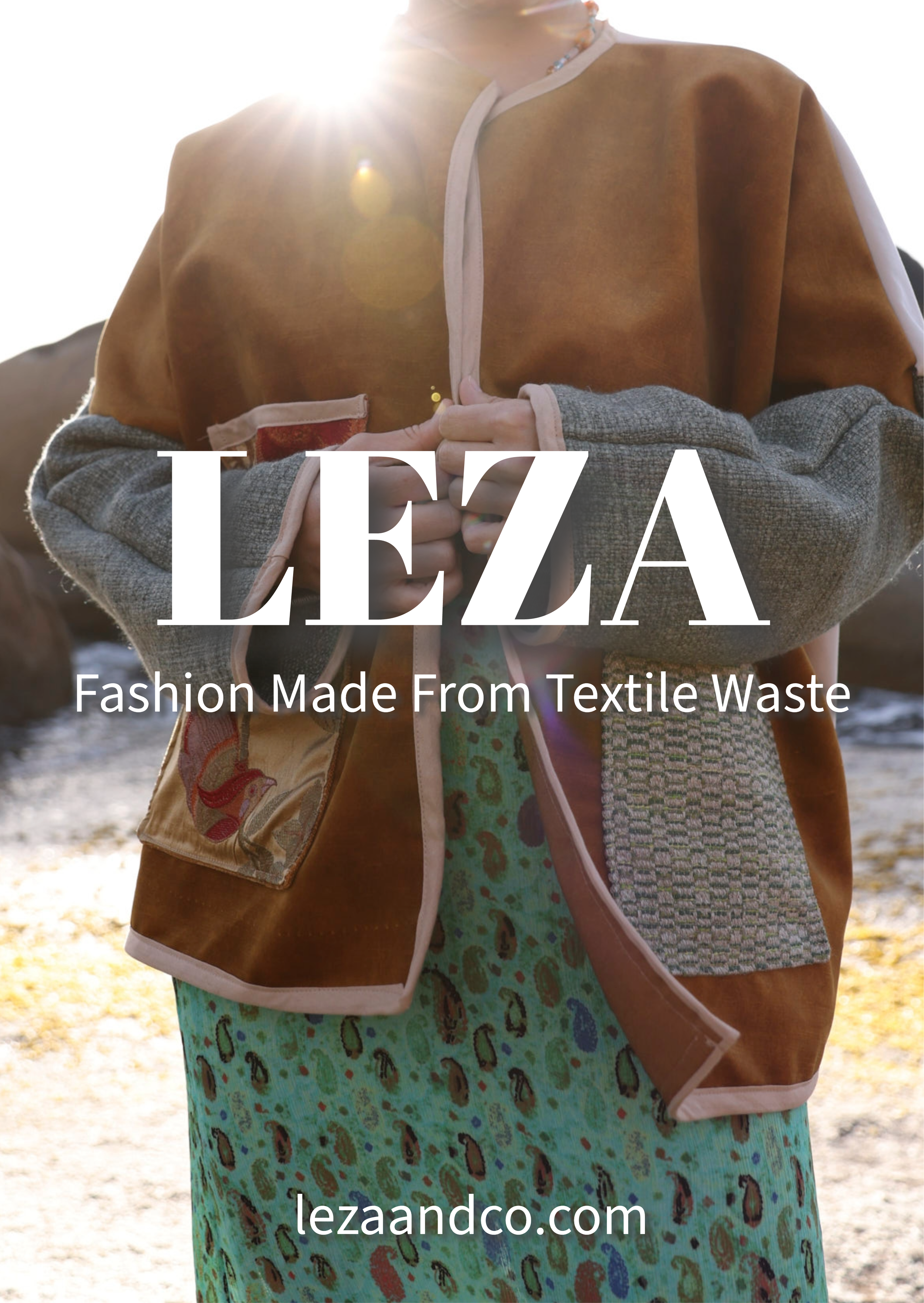 Een persoon draagt een jas van LEZA uit Zuid Afrika met textieldetails en een groene, dierenprint rok. De persoon staat buiten in zonlicht.