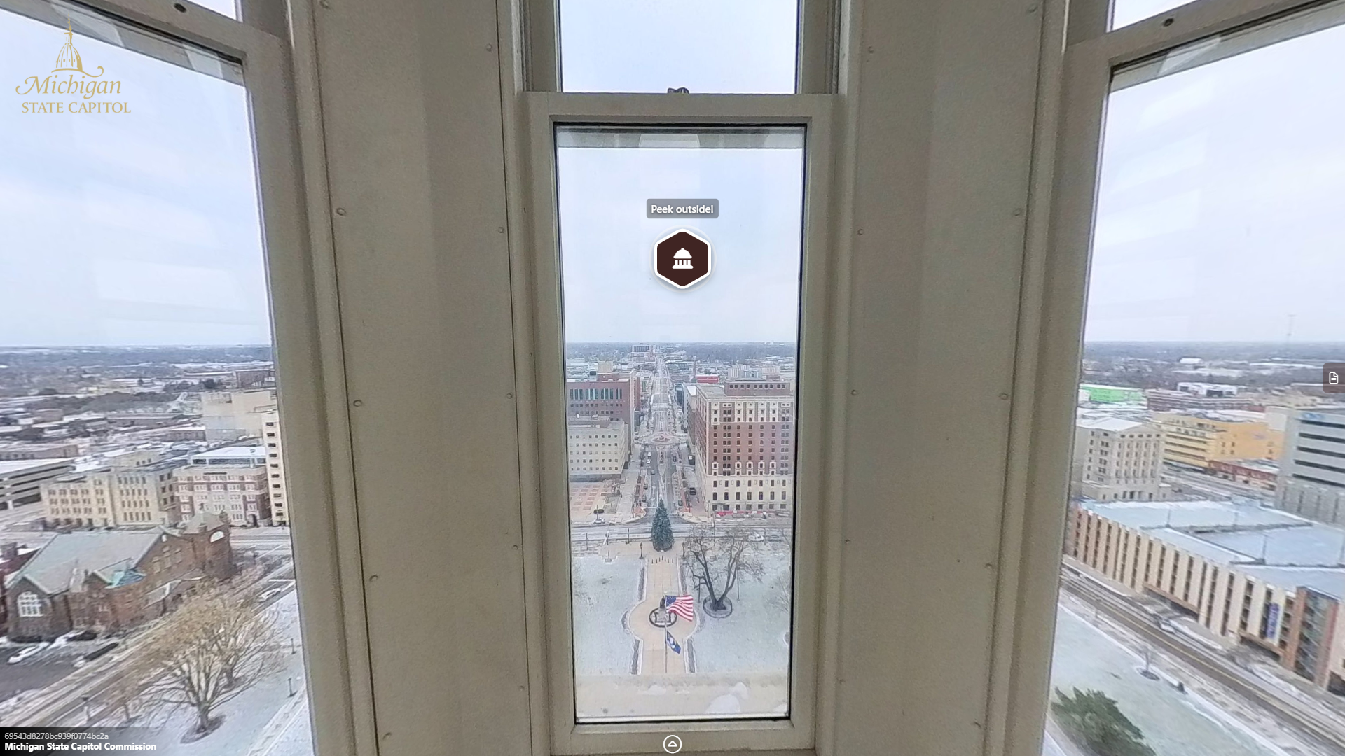 image of a view through a set of windows showing the capitol lawn and the buildings and streets that surround it.