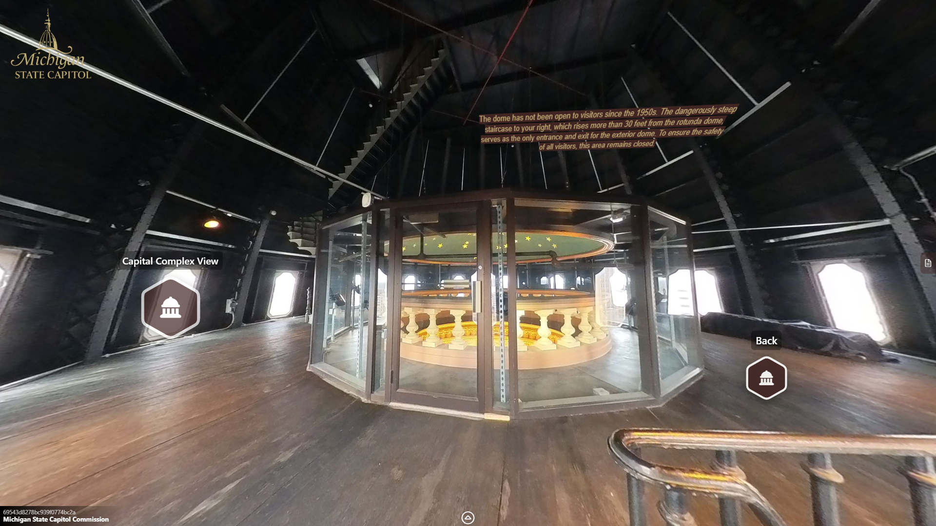 image of a large open space with windows inside of the dome with large black metal trusses extending upwards, a staircase rising int he middle of the space toward the ceiling, and a glass enclosure encircling the oculus railing.